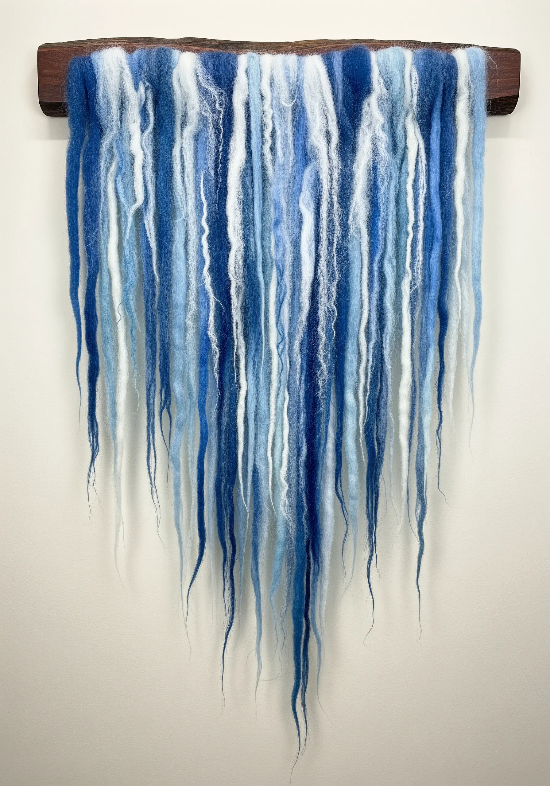 A wall hanging made of long strands of blue and white unspun wool roving.