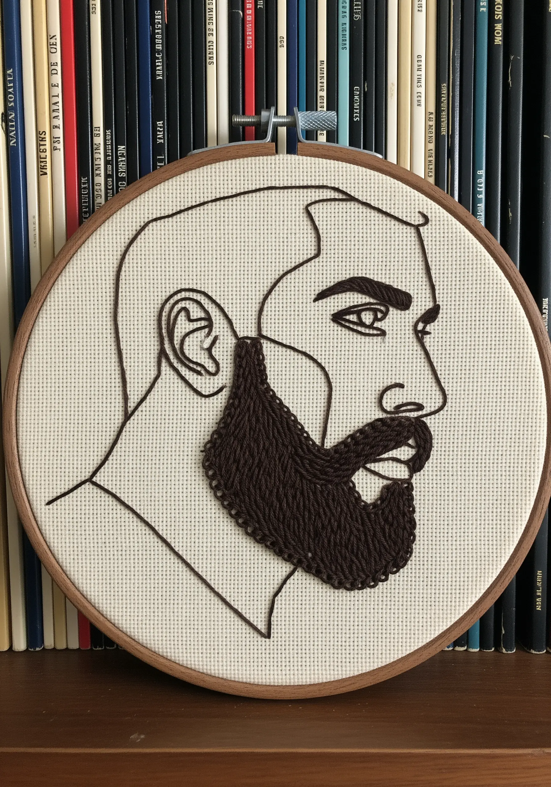 A line art portrait of a man, with the beard filled in using a dense, brown chain stitch.