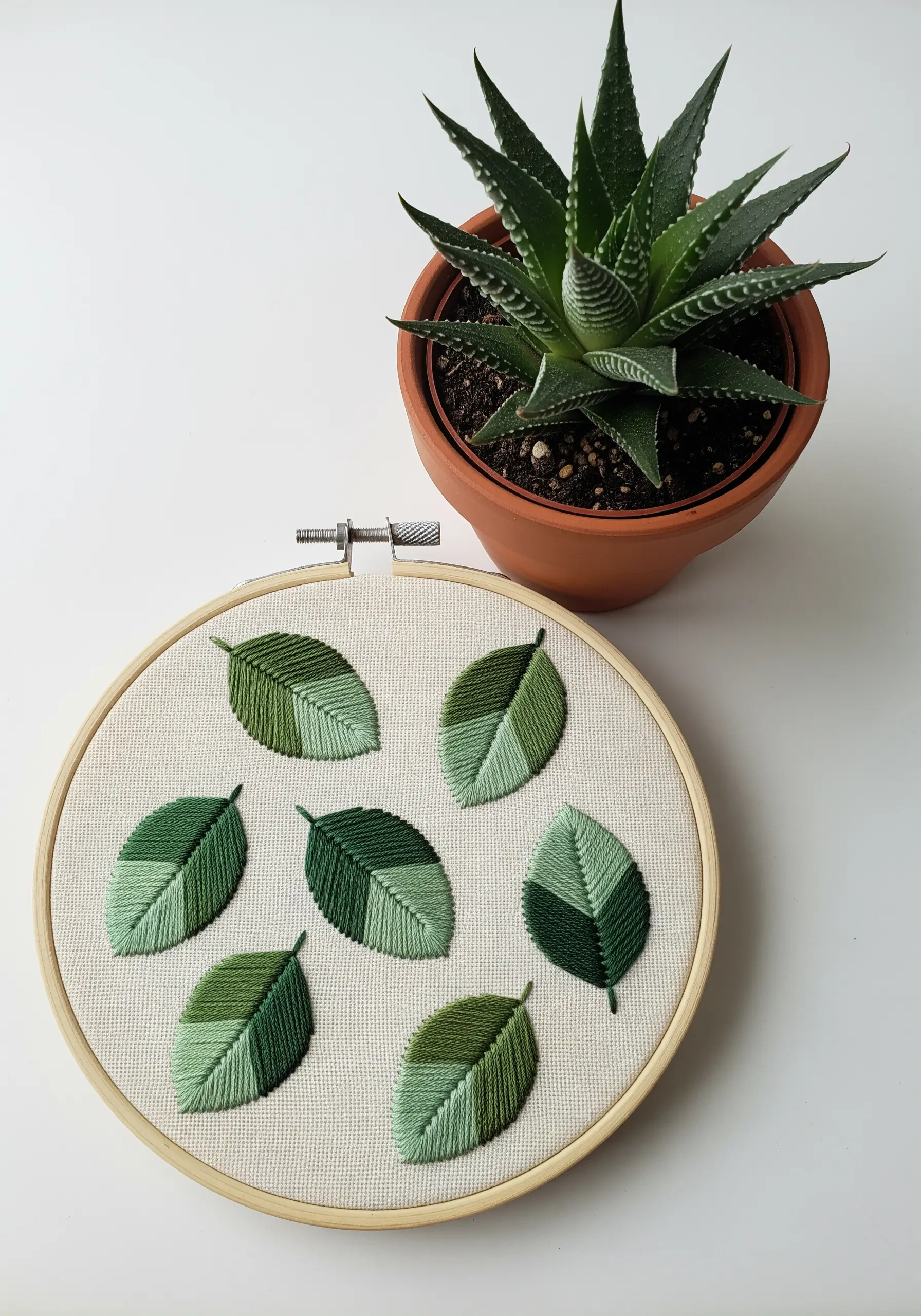 A collection of embroidered leaves, each filled with two different shades of green.