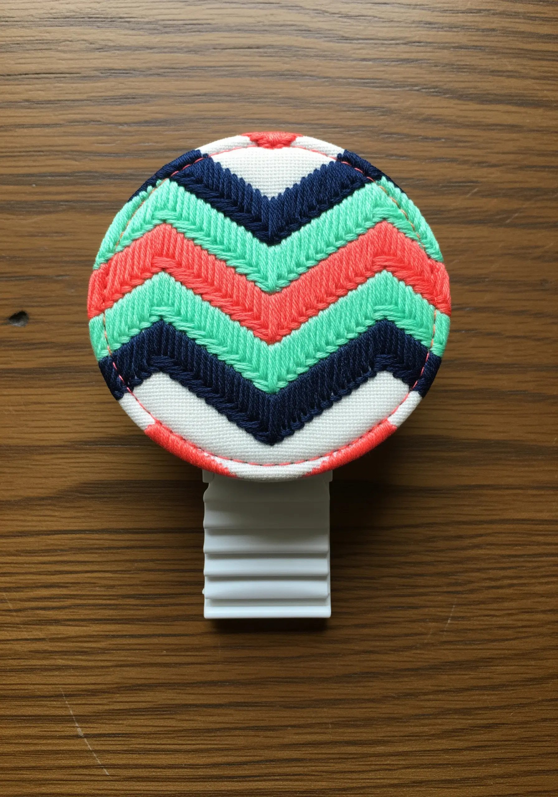 A car air freshener covered in a vibrant chevron pattern stitched in herringbone.