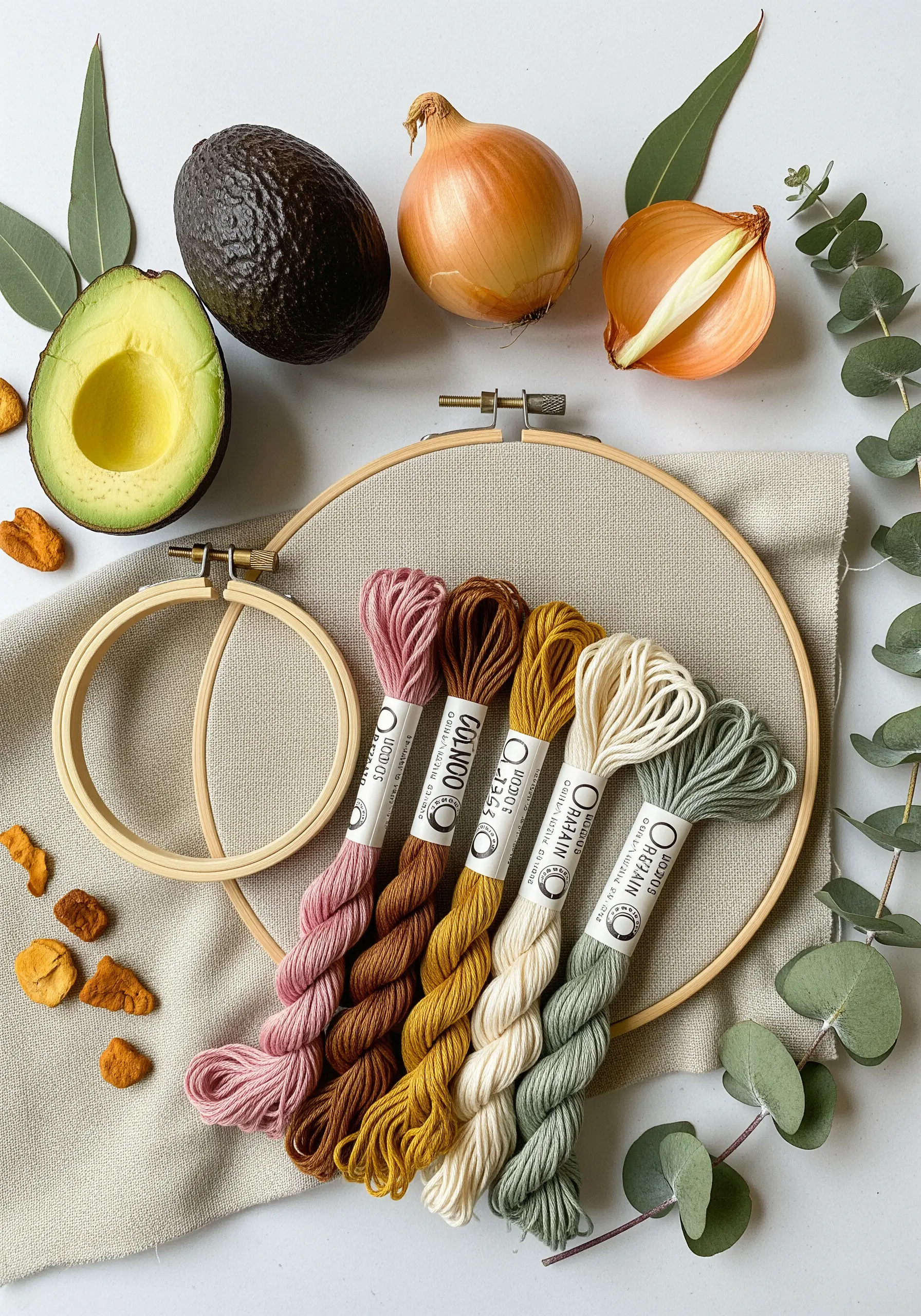 Skeins of organic cotton thread in earthy pink, brown, yellow, and green from natural dyes.