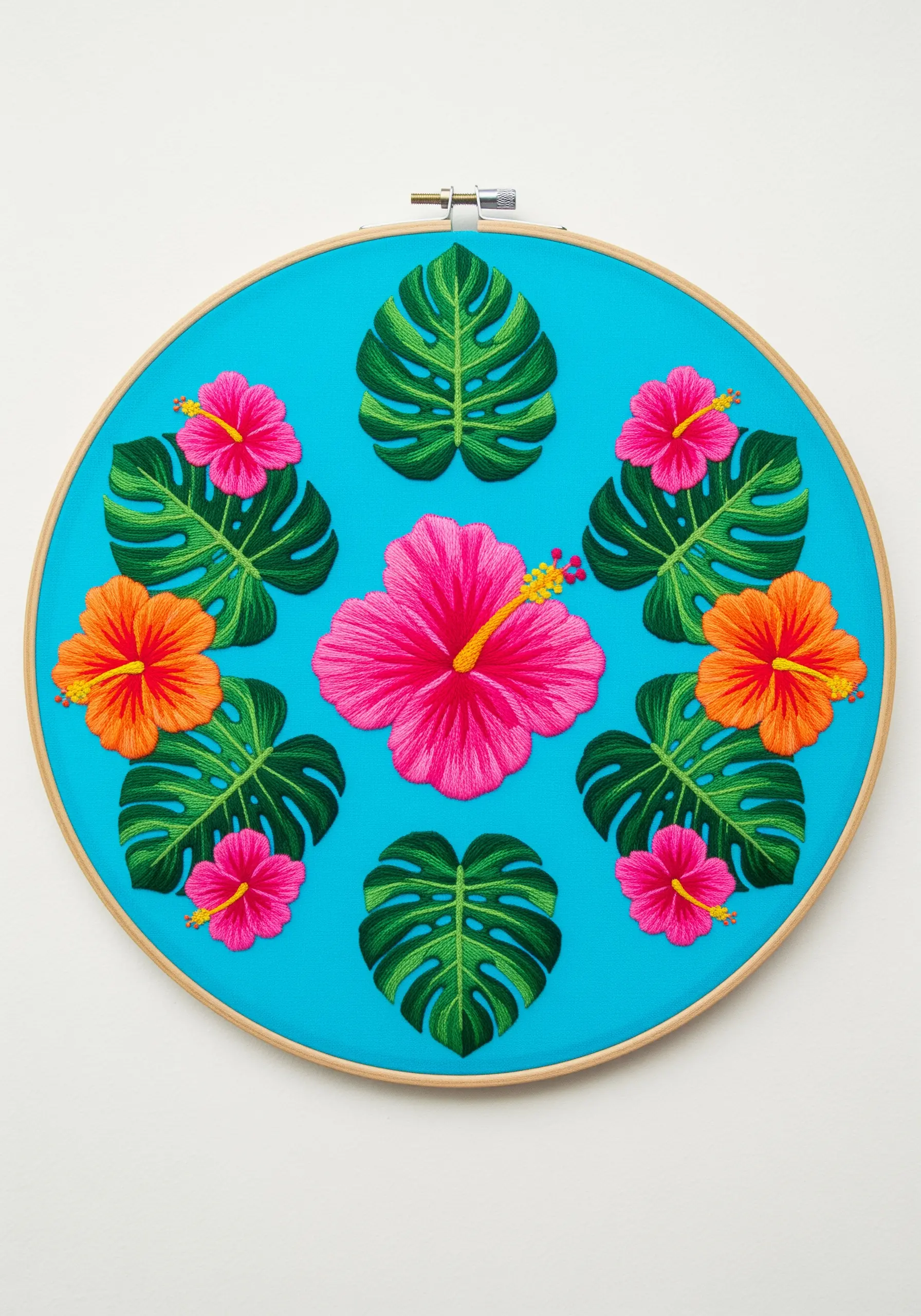 A tropical mandala with hibiscus flowers and monstera leaves on bright blue fabric.