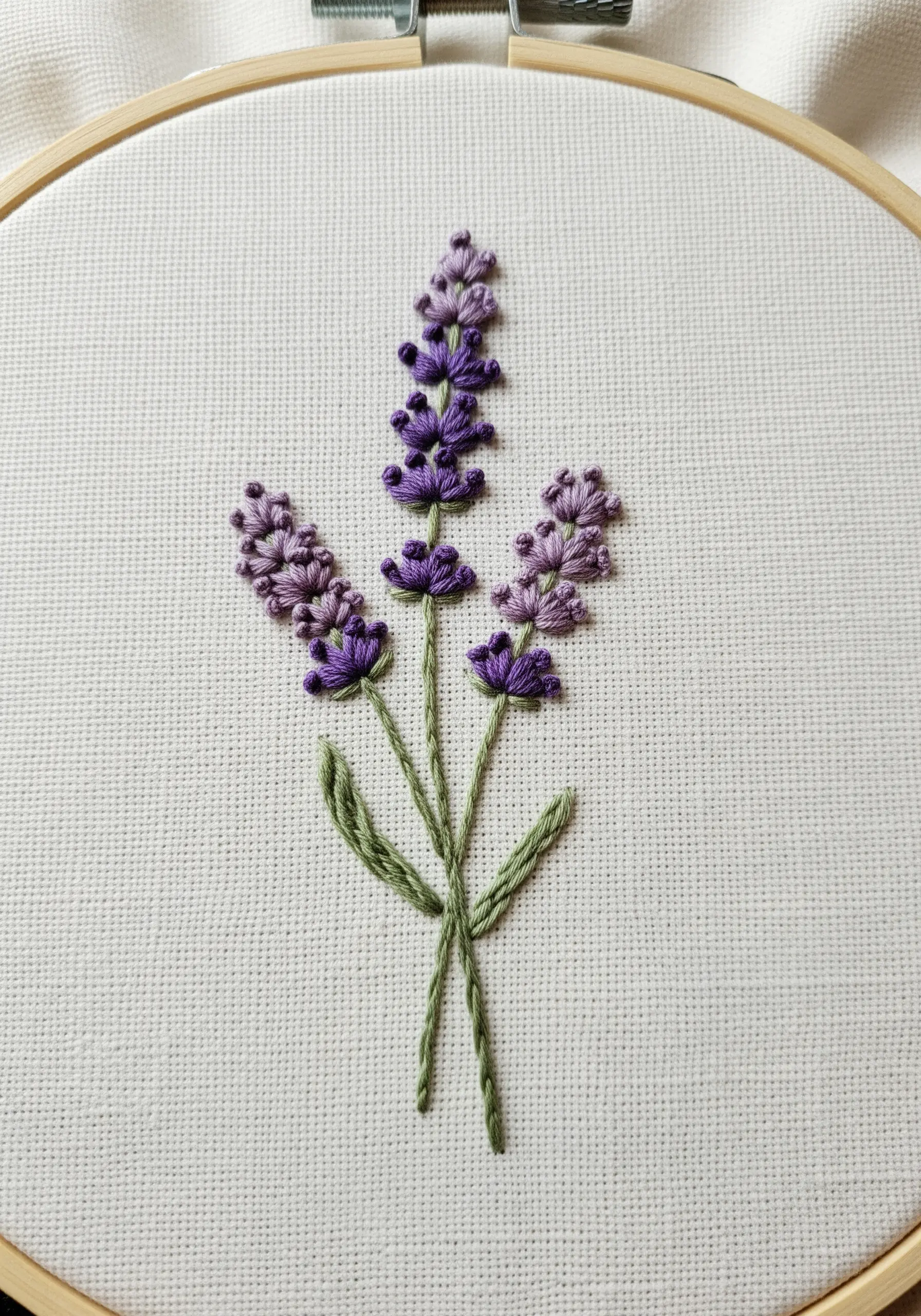 Three lavender stalks embroidered with purple French knots and green split stitch stems.