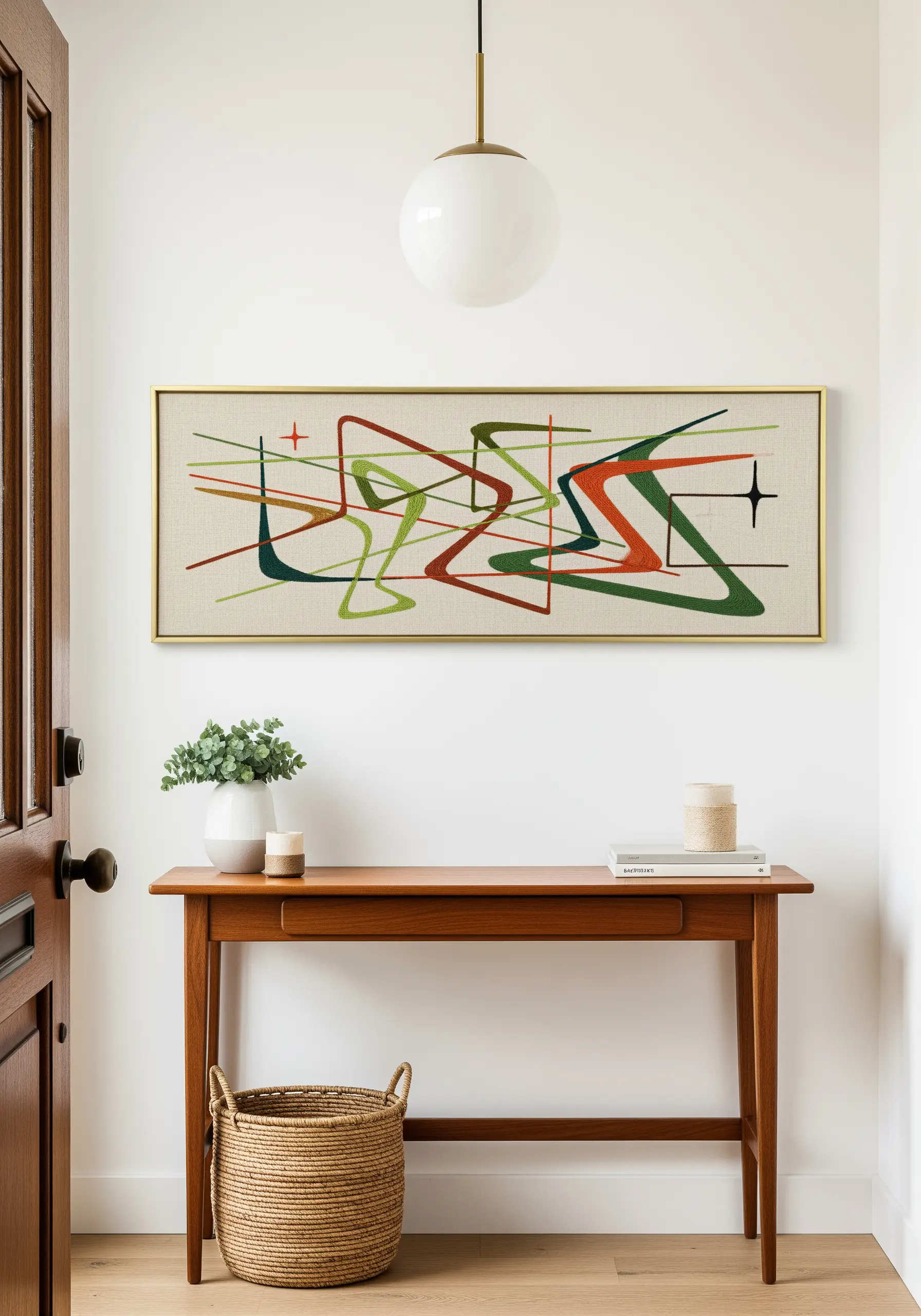 A wide, framed mid-century modern embroidery with abstract shapes and lines.