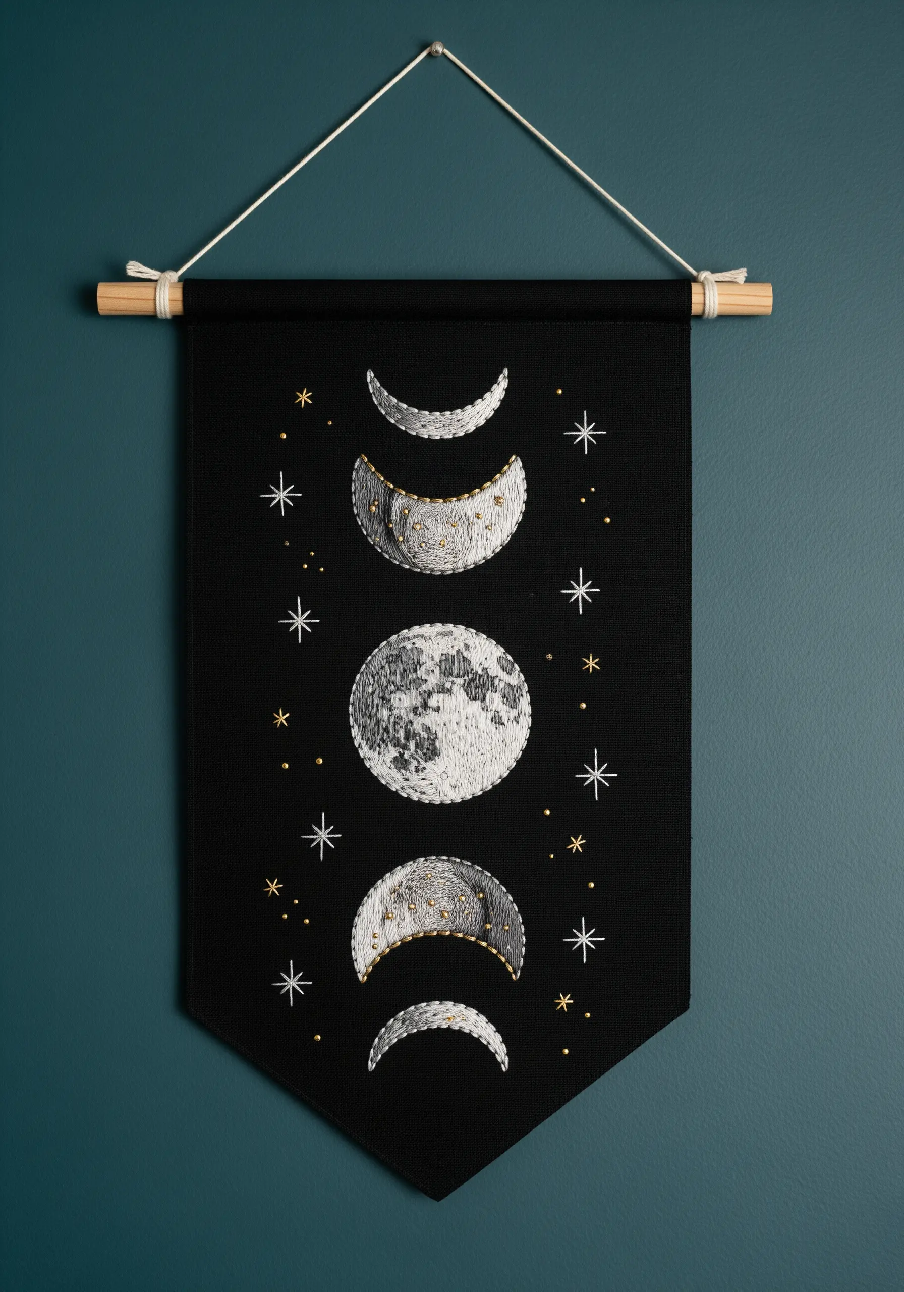 Embroidered moon phases on a black wall banner, with texture and metallic details.
