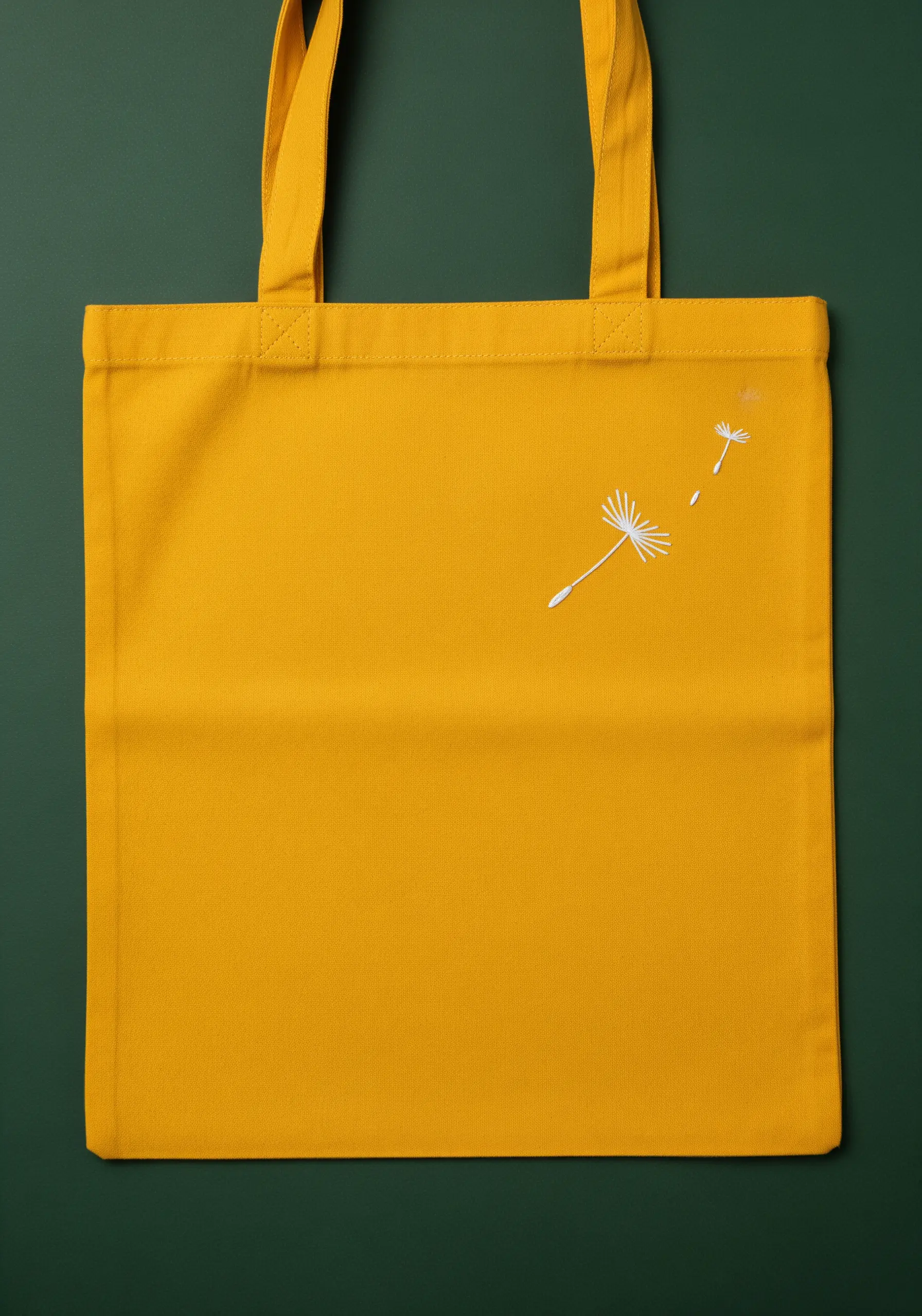 Delicate white dandelion seeds blowing across a vibrant yellow tote bag.