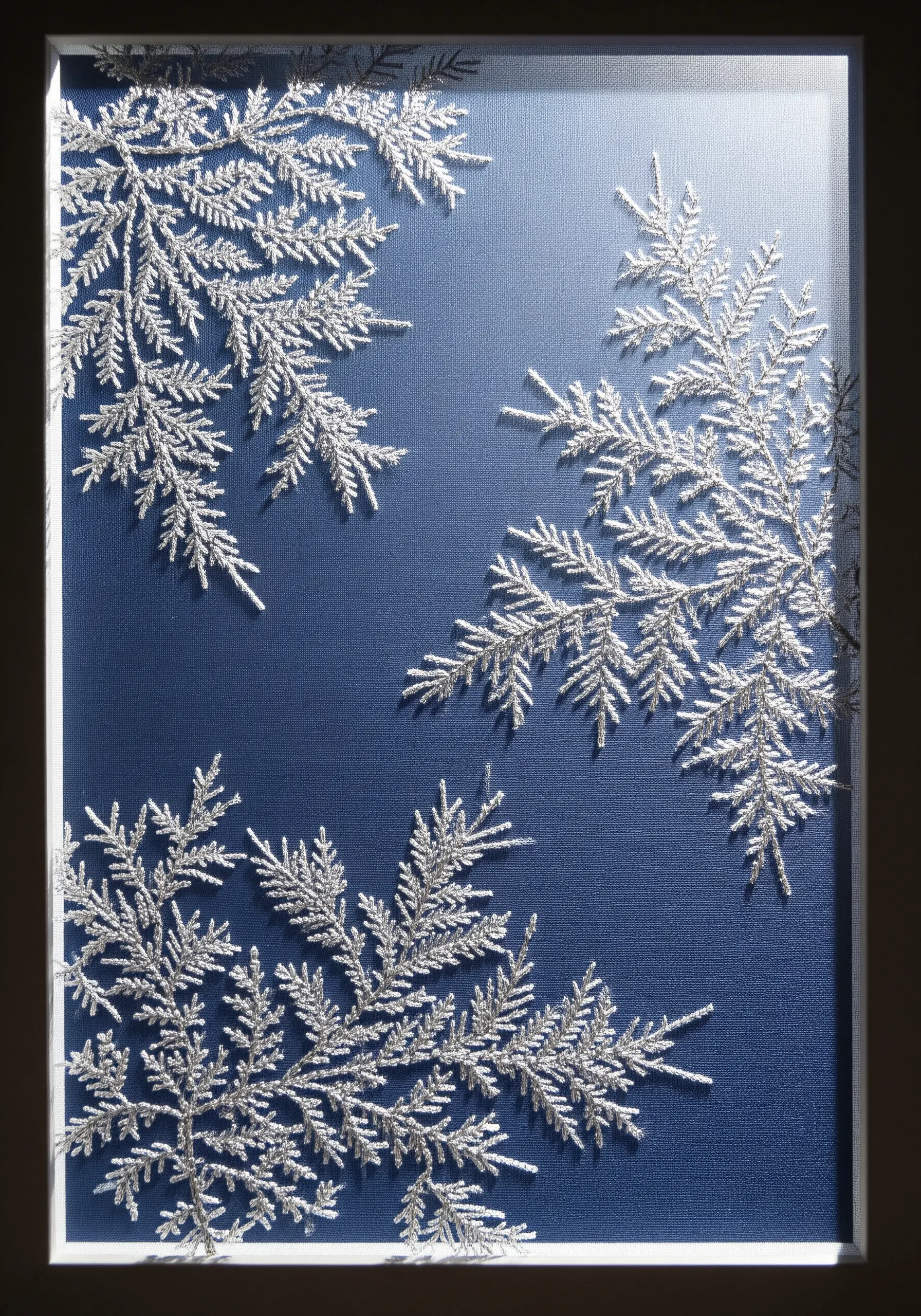 Silver metallic thread embroidered as frosted branches against a dark blue canvas.