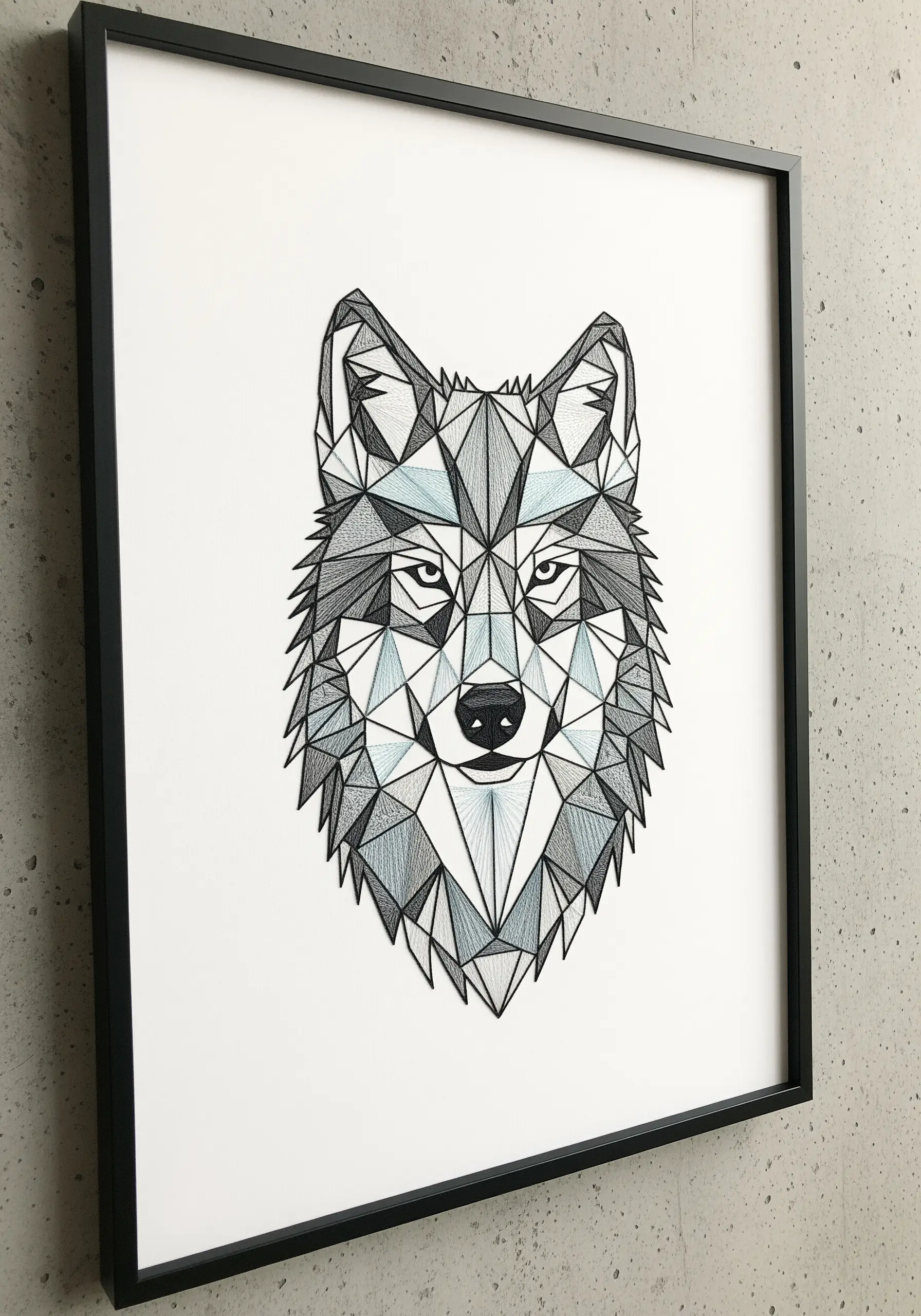 A framed geometric portrait of a wolf, created with straight stitches in shades of grey and blue.