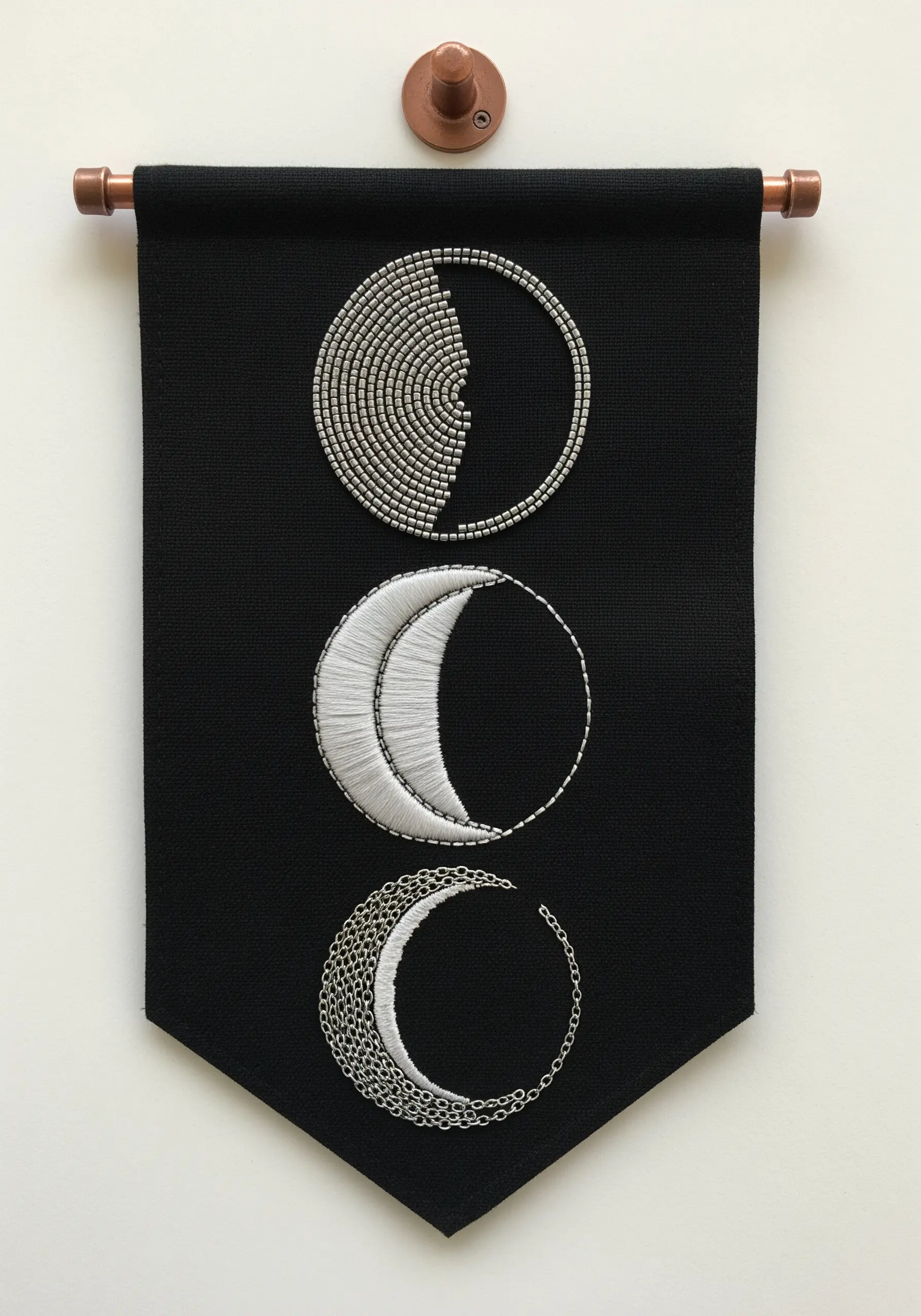 Black wall banner with three moon phases created with beads, thread, and chain.
