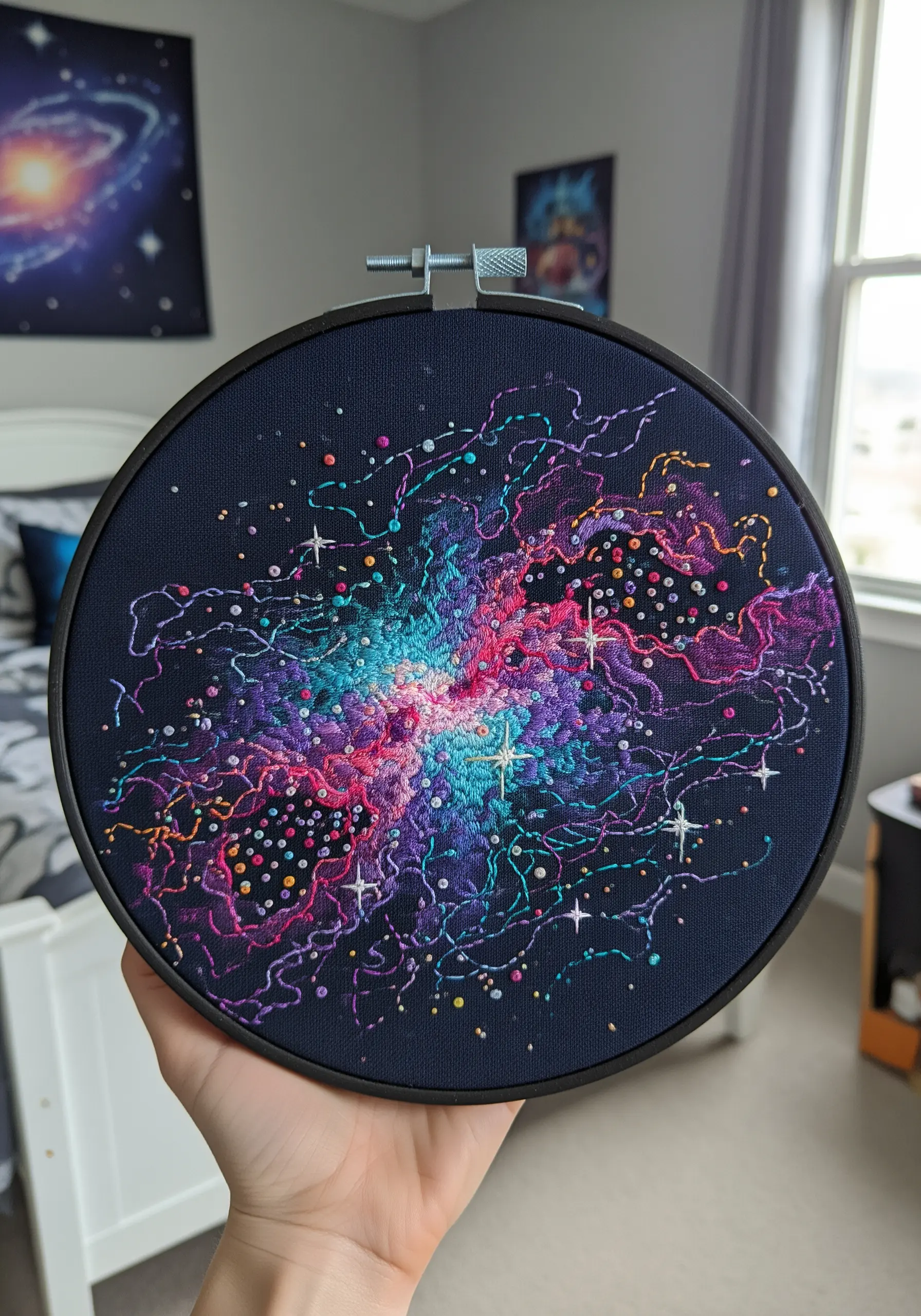A vibrant embroidery of a cosmic nebula in a hoop, using variegated and bright threads.