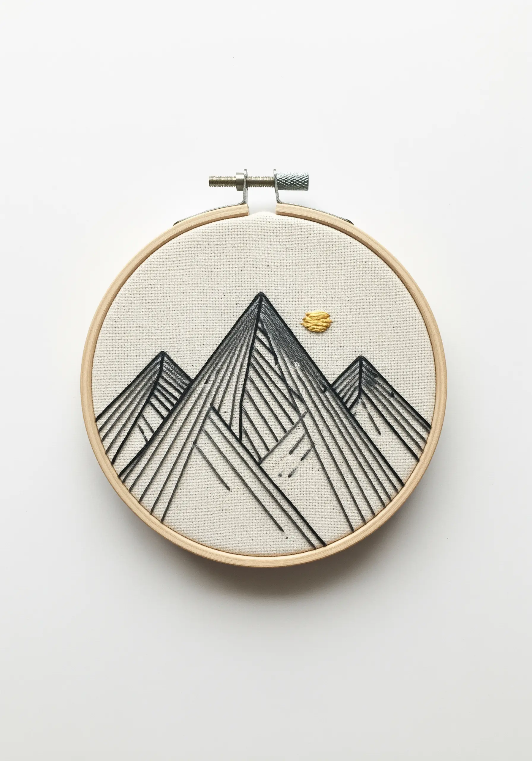 A minimalist mountain range in black line art with a small golden sun.