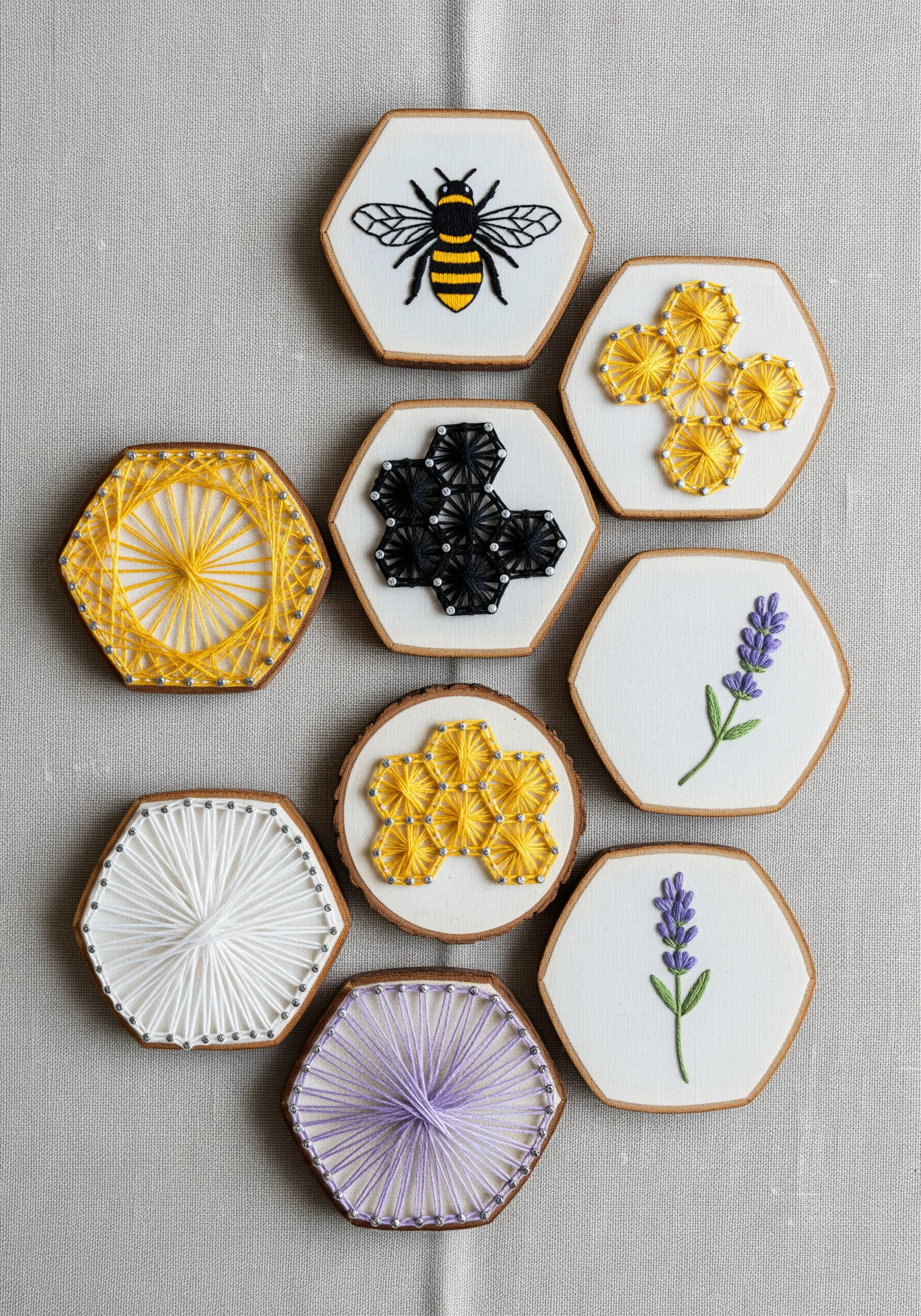 A collection of small hexagonal frames with bee-themed string art and embroidery designs.