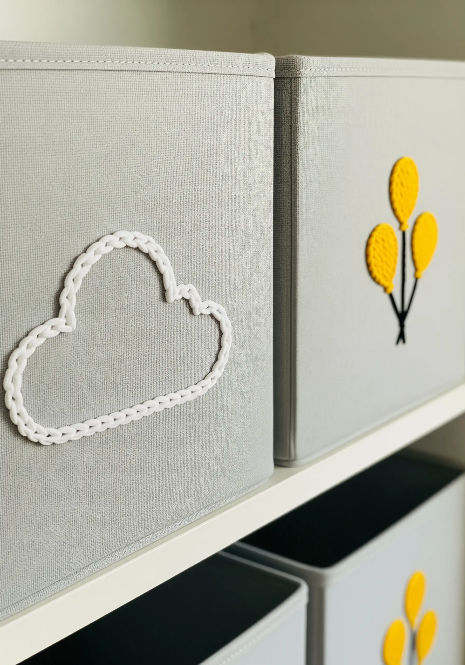 A simple couched yarn outline of a cloud on a grey fabric storage box.