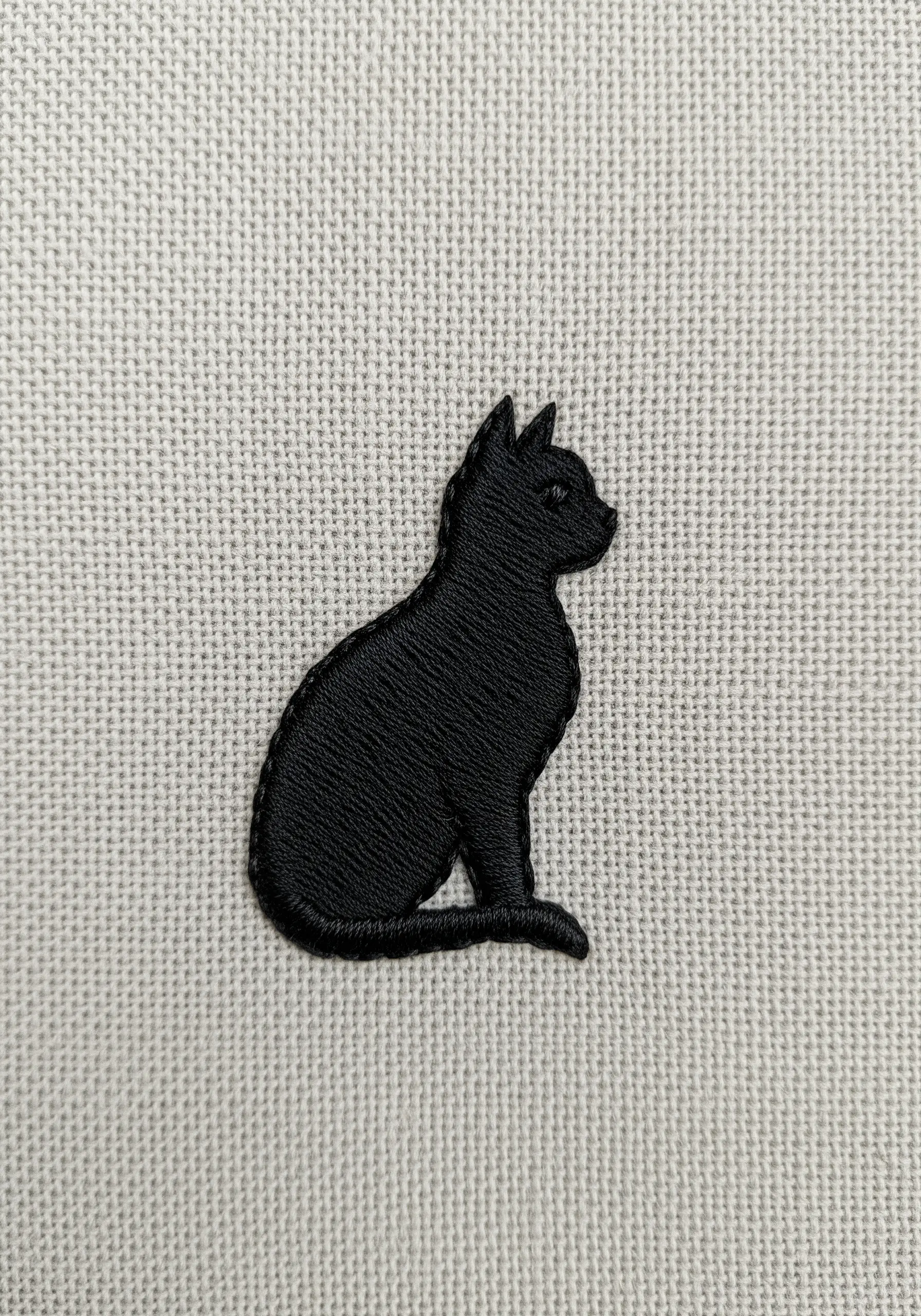 A solid black cat silhouette embroidered with a perfectly sharp satin stitch edge.
