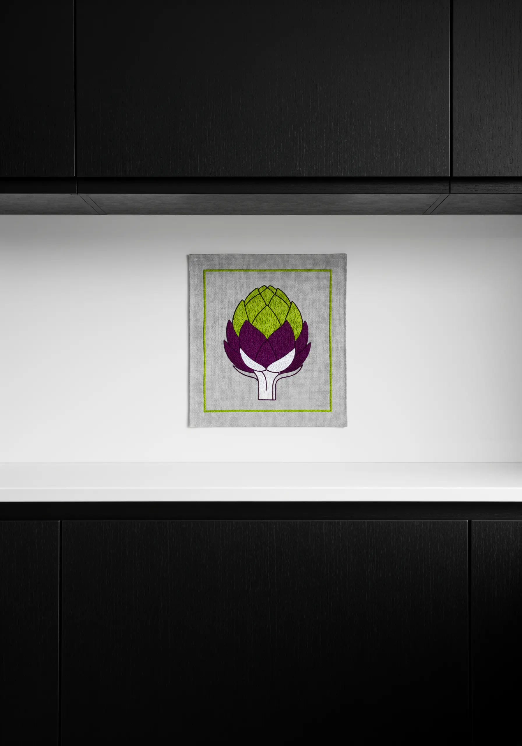 A graphic embroidery of an artichoke with a bright green outline.
