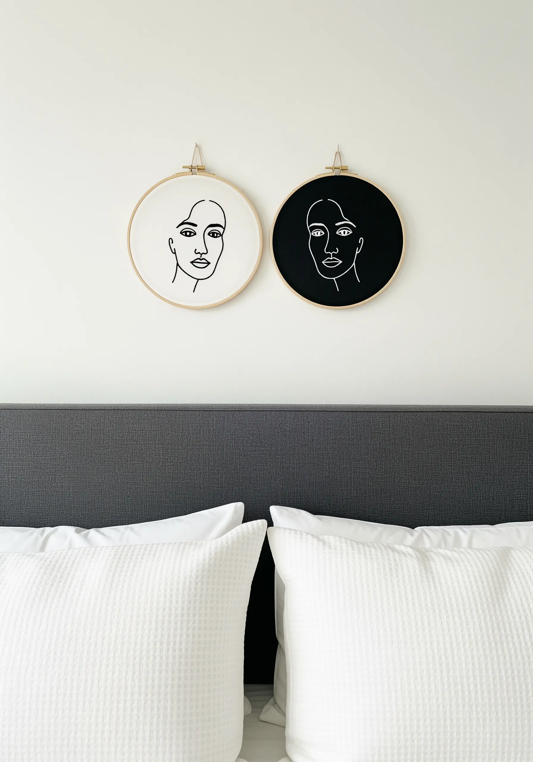Two hoops hung as a pair: one with a black line face on white, the other white on black.