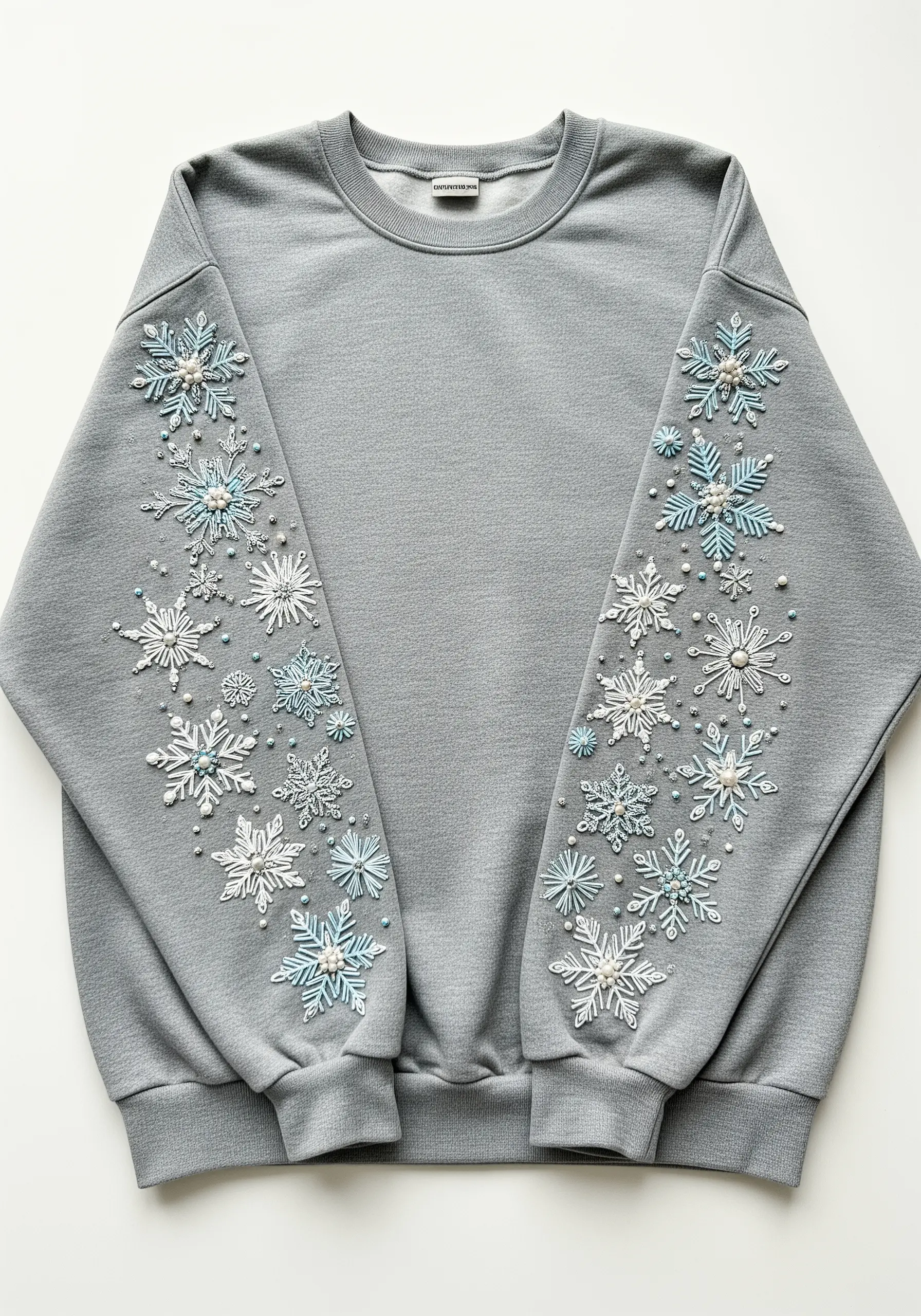 Beaded and embroidered snowflakes in blue and white on grey sweatshirt sleeves.