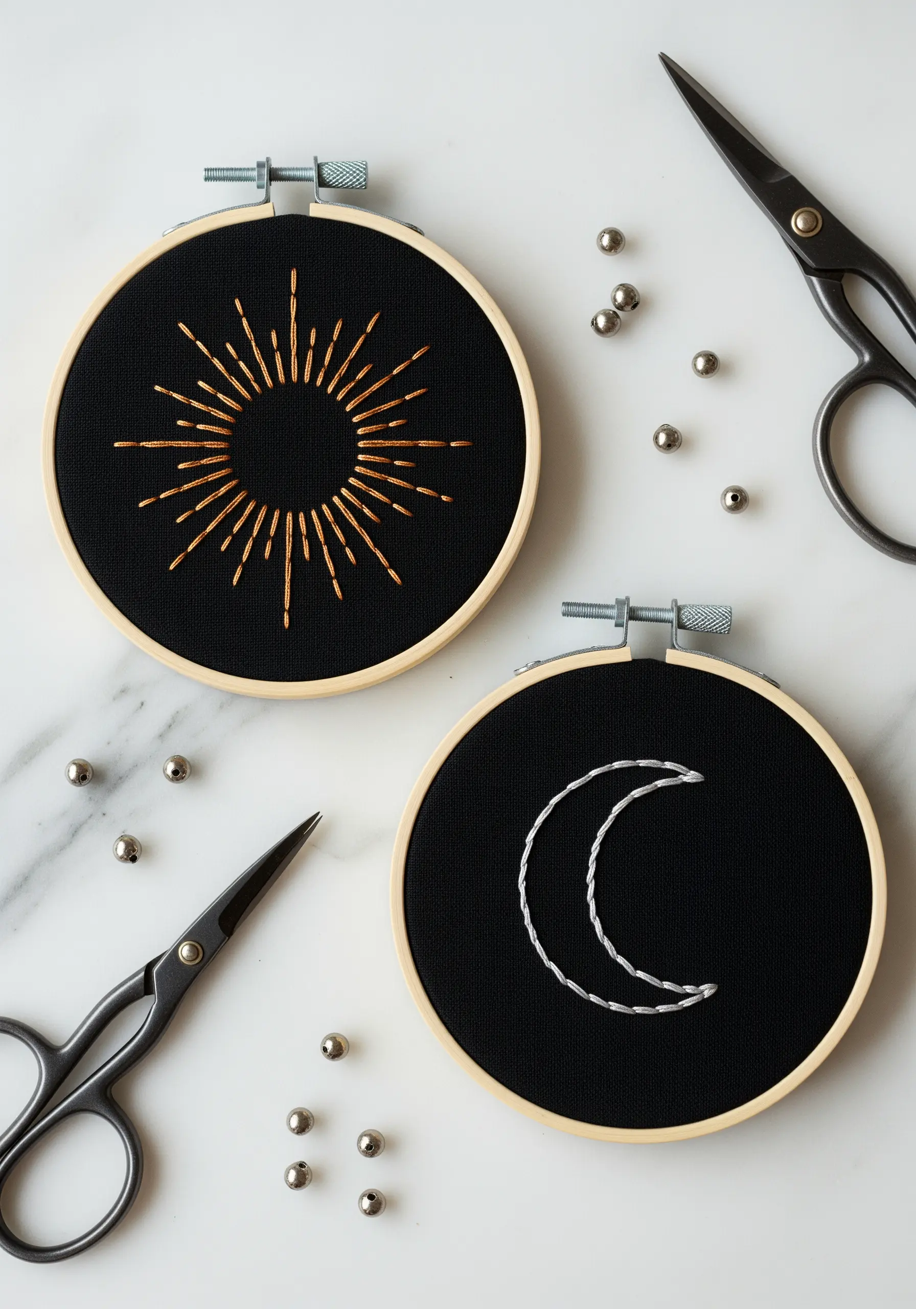 Two hoops on black fabric: a copper sunburst and a silver crescent moon.
