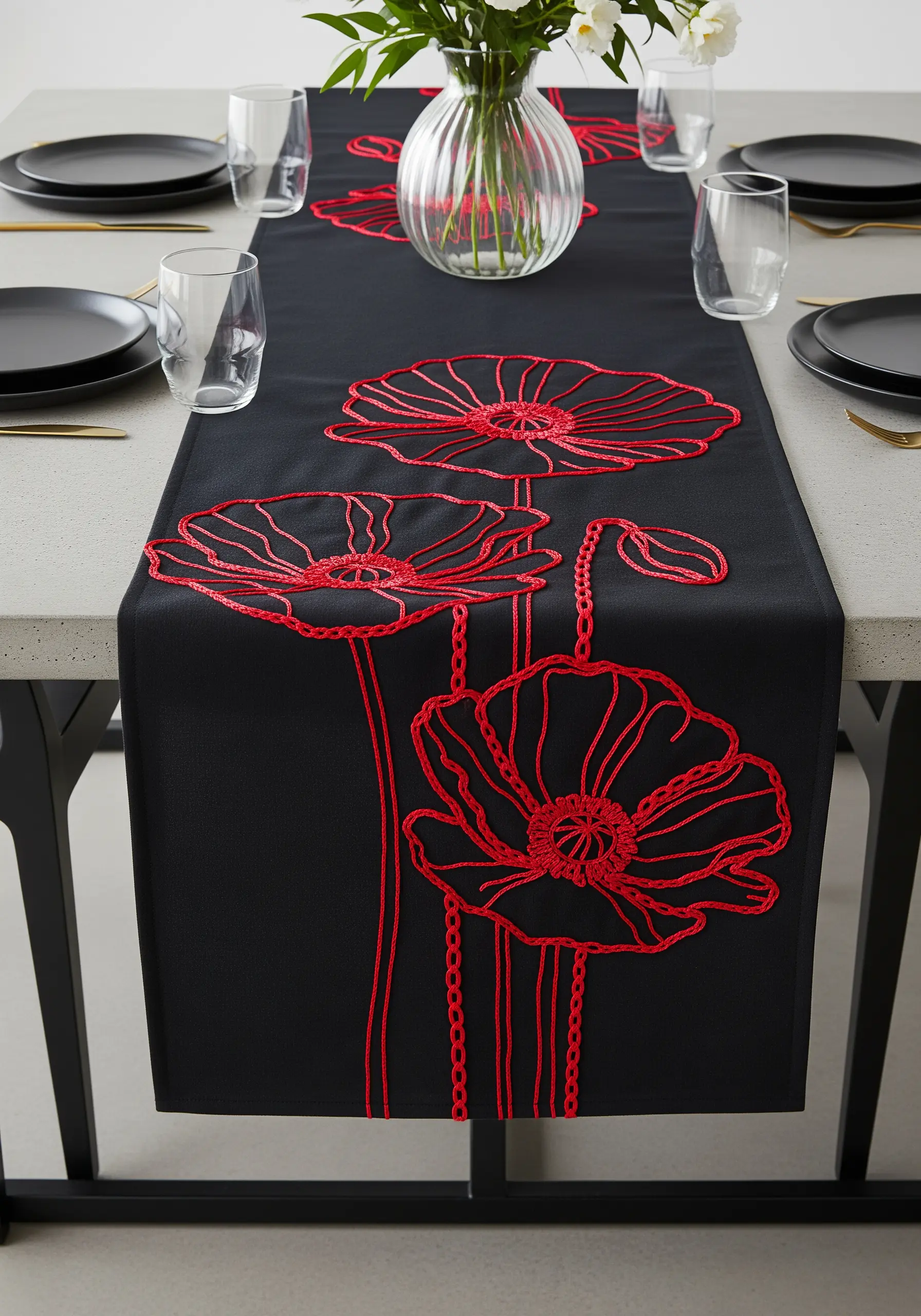 Bold red chain stitch embroidery of poppies on a black table runner.