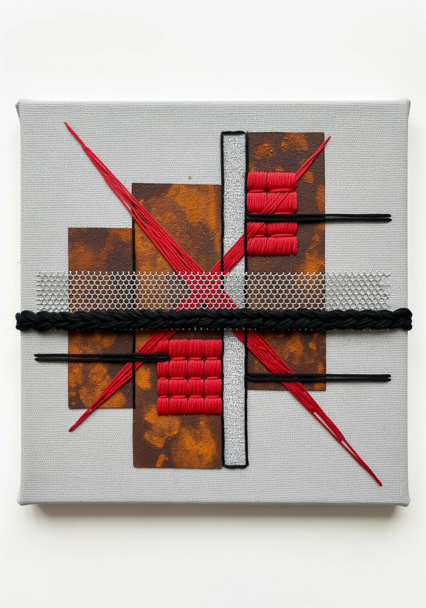 Geometric abstract embroidery on canvas with red satin stitch blocks and silver mesh.