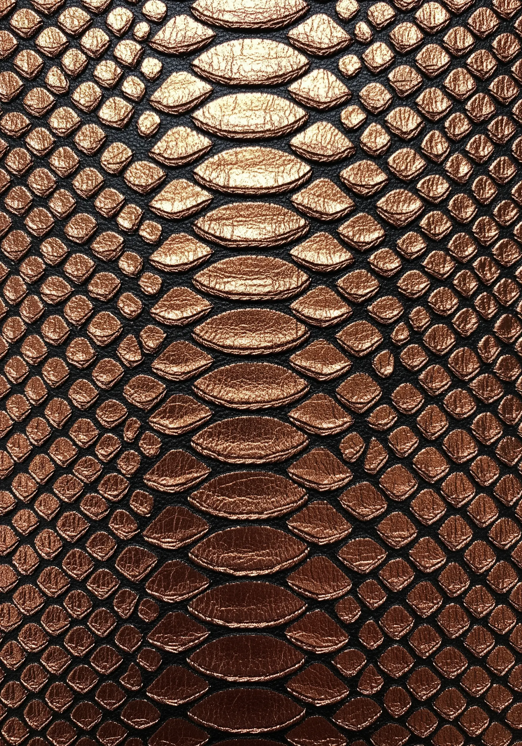 Close-up of an embroidered snakeskin pattern using metallic variegated copper thread.