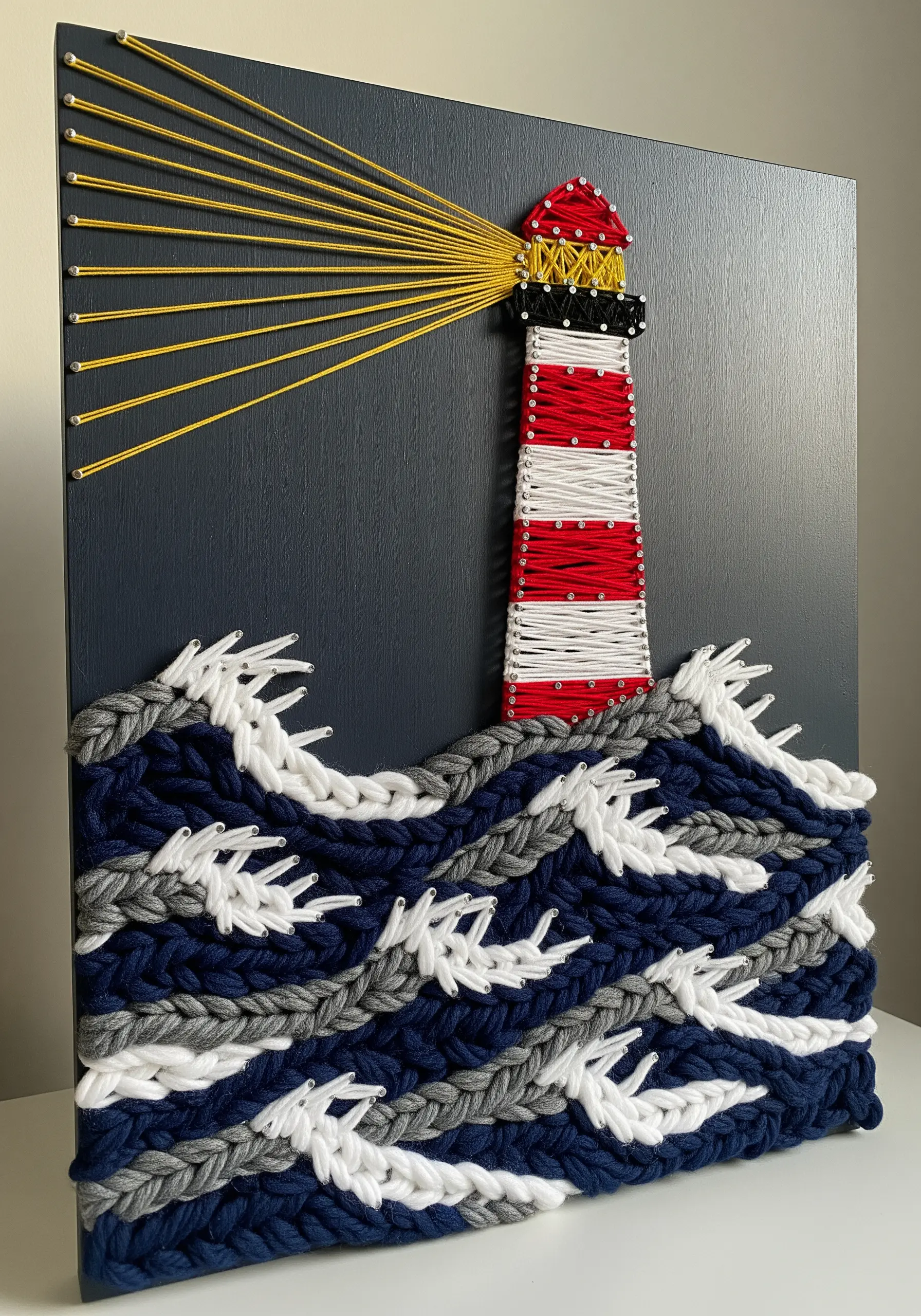 Lighthouse string art with chunky braided yarn for waves and thin yellow thread for light.