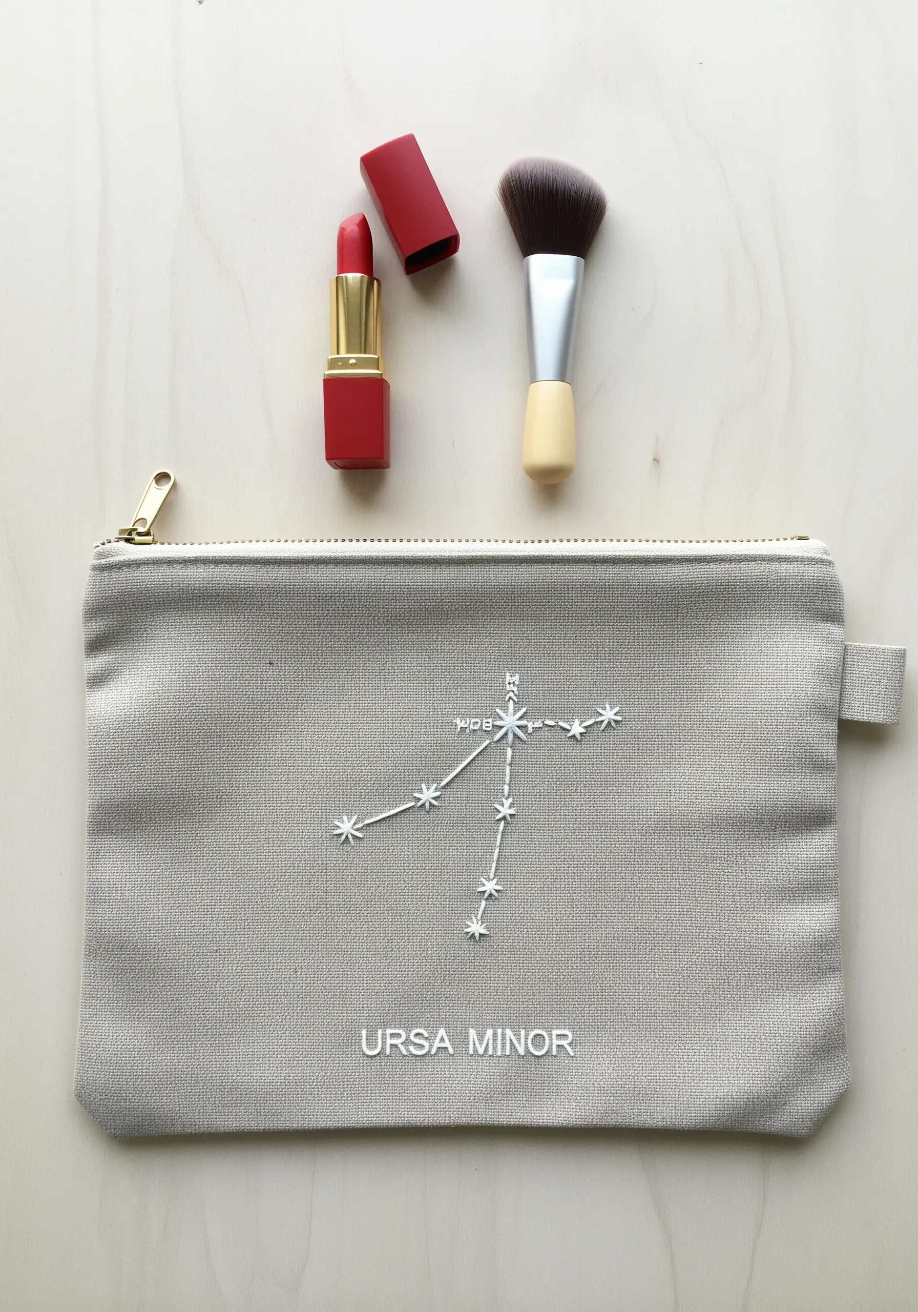The Ursa Minor constellation embroidered in white thread on a canvas pouch.