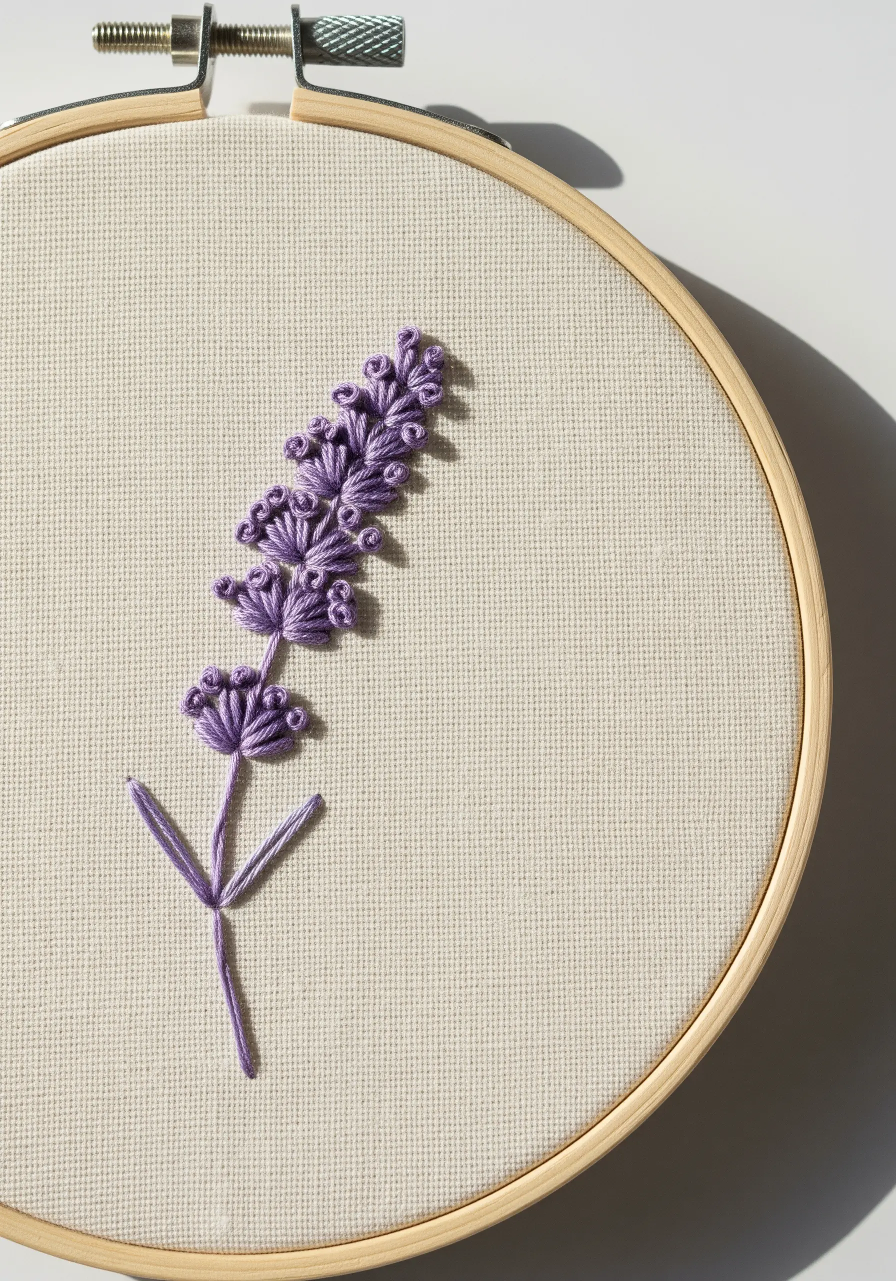 A single lavender sprig embroidered with purple French knots and a straight stitch stem.