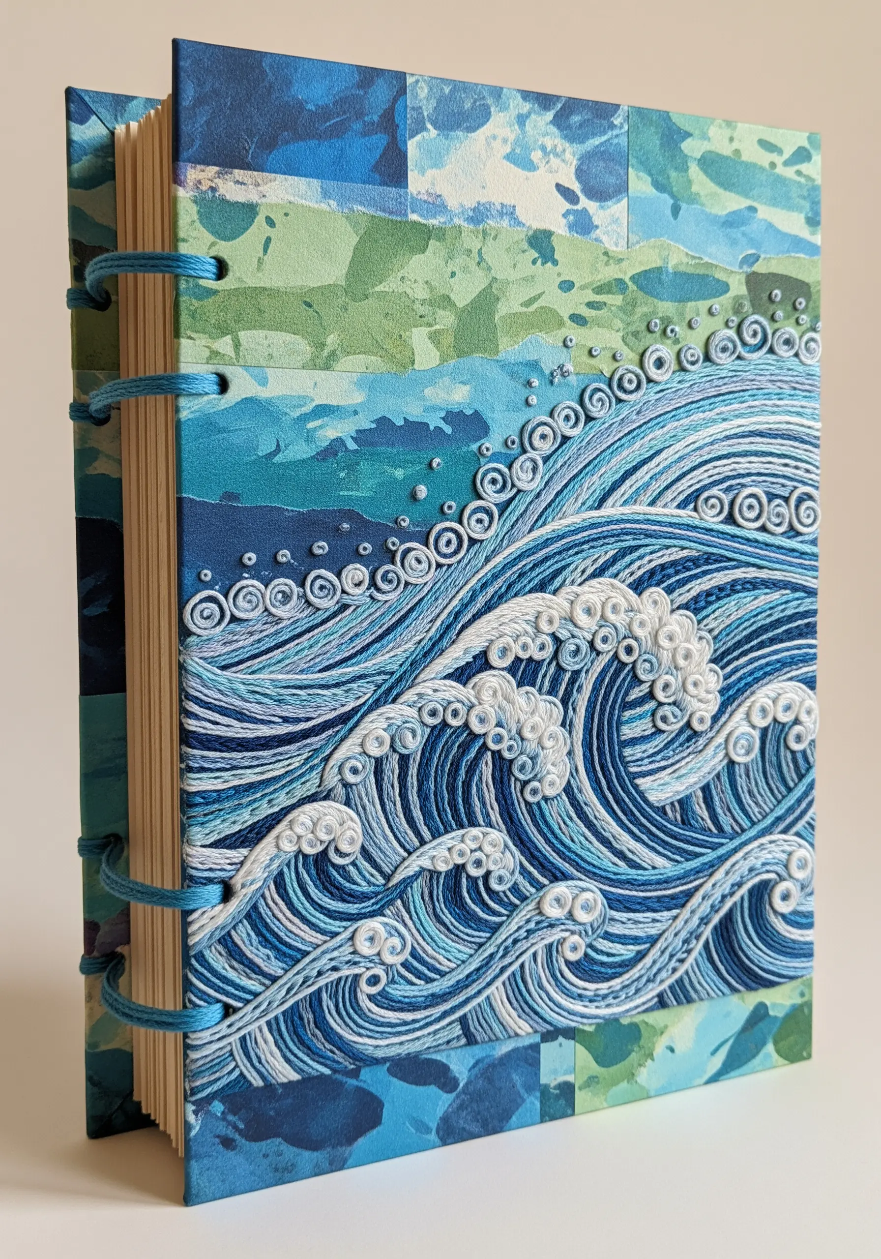 A journal cover with a highly textured embroidered ocean wave scene using French knots and couching.