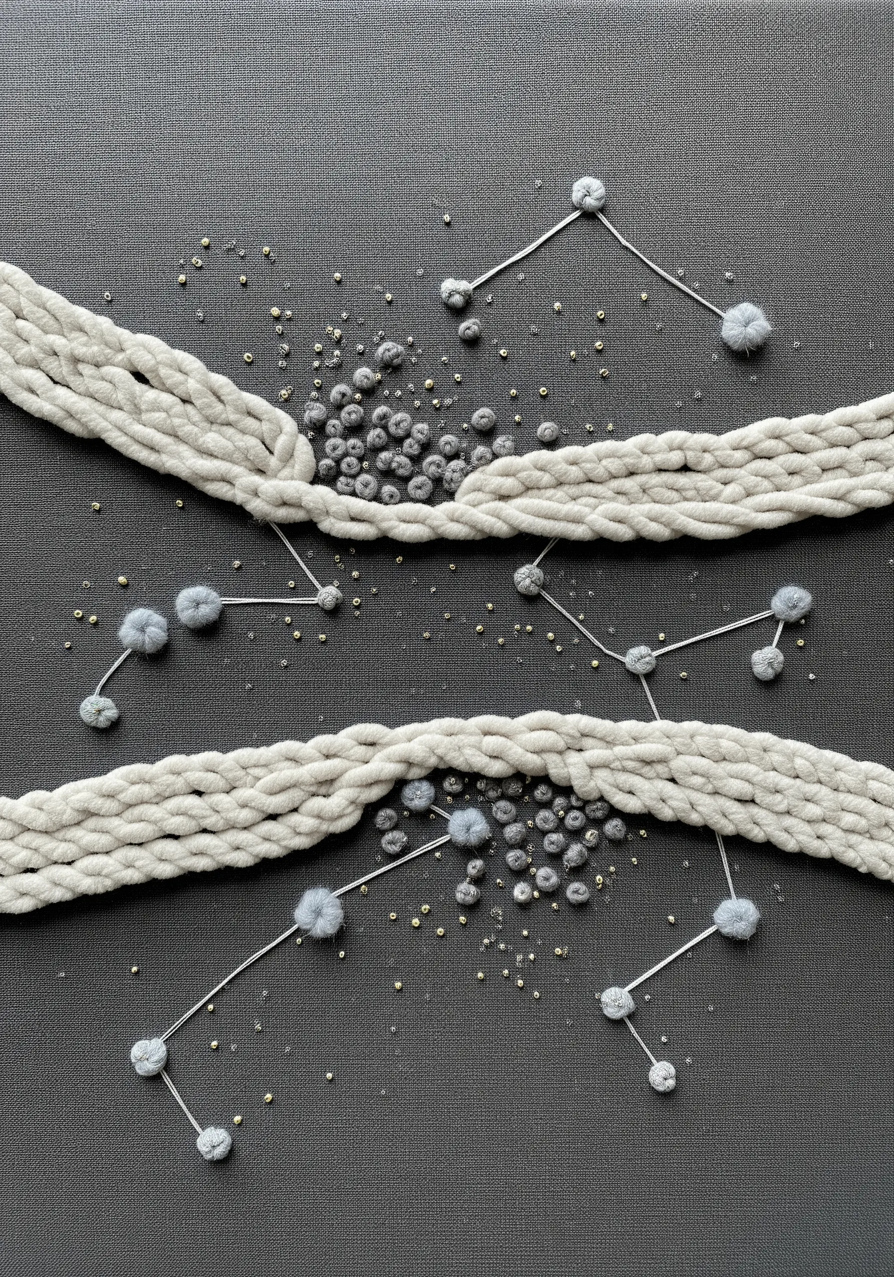 Abstract constellation art on dark fabric using twisted yarn, fuzzy pompoms, and seed beads.