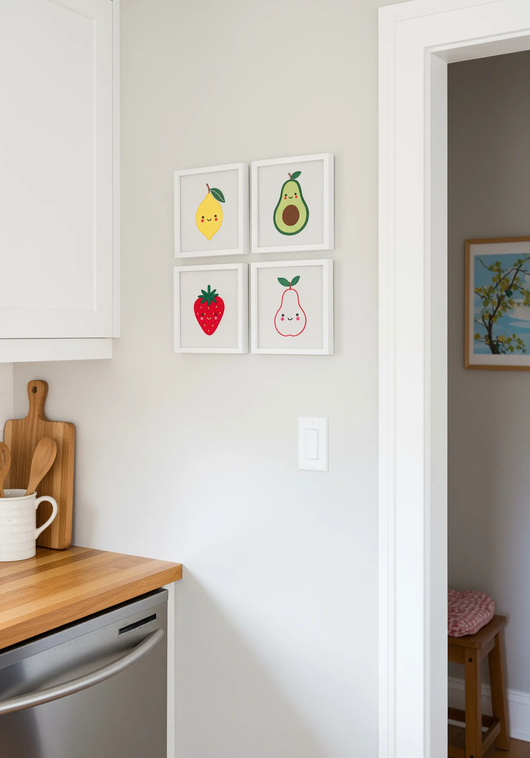 Four small framed artworks of cute, smiling fruit characters: a lemon, avocado, strawberry, and pear.
