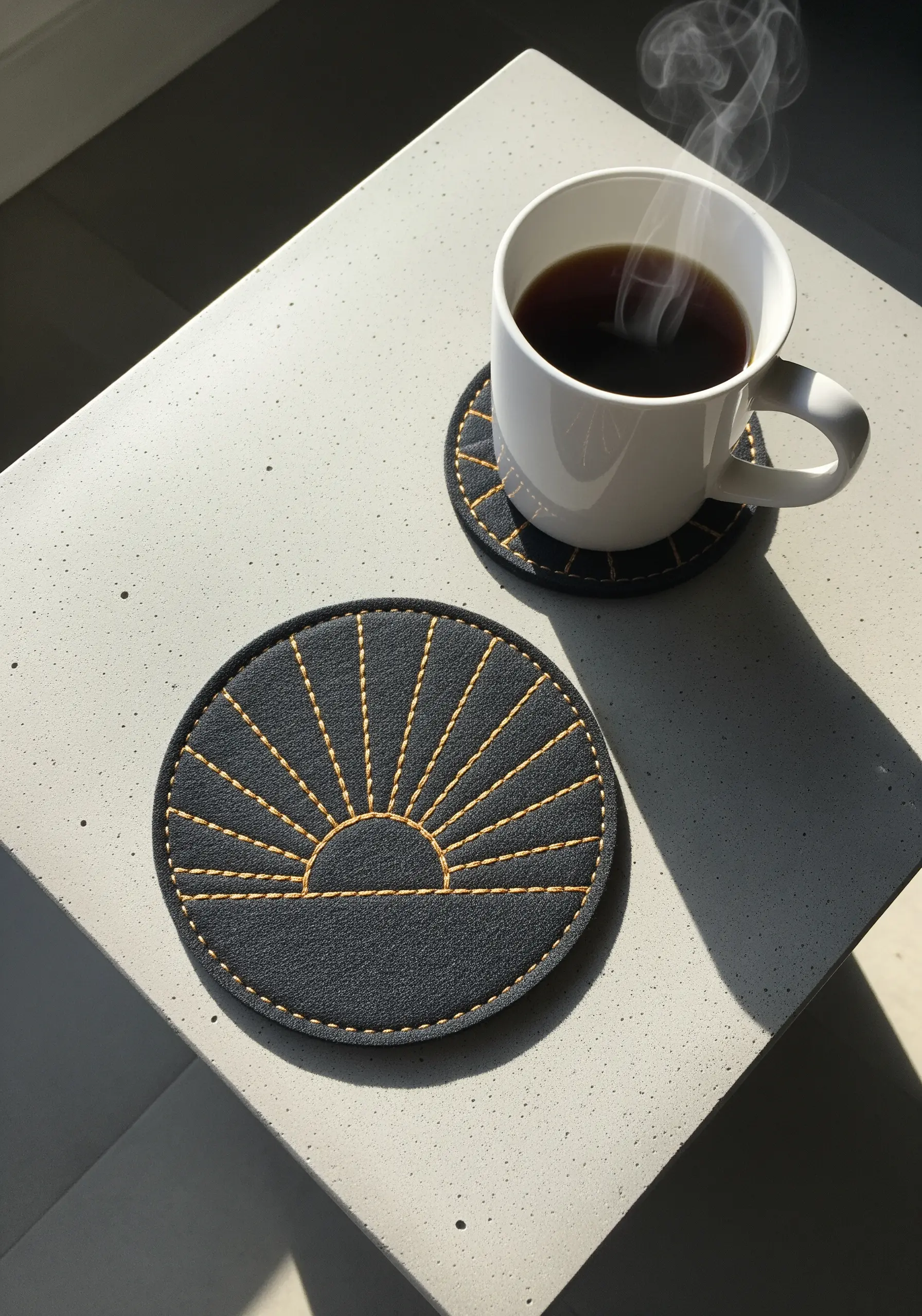 Modern embroidered sunburst coaster in dark gray felt with golden thread.