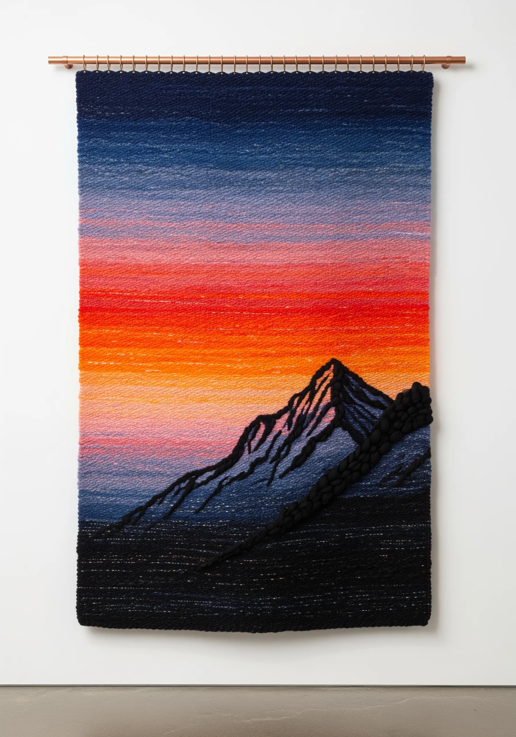 Woven sunset wall art with a textured black mountain silhouette.