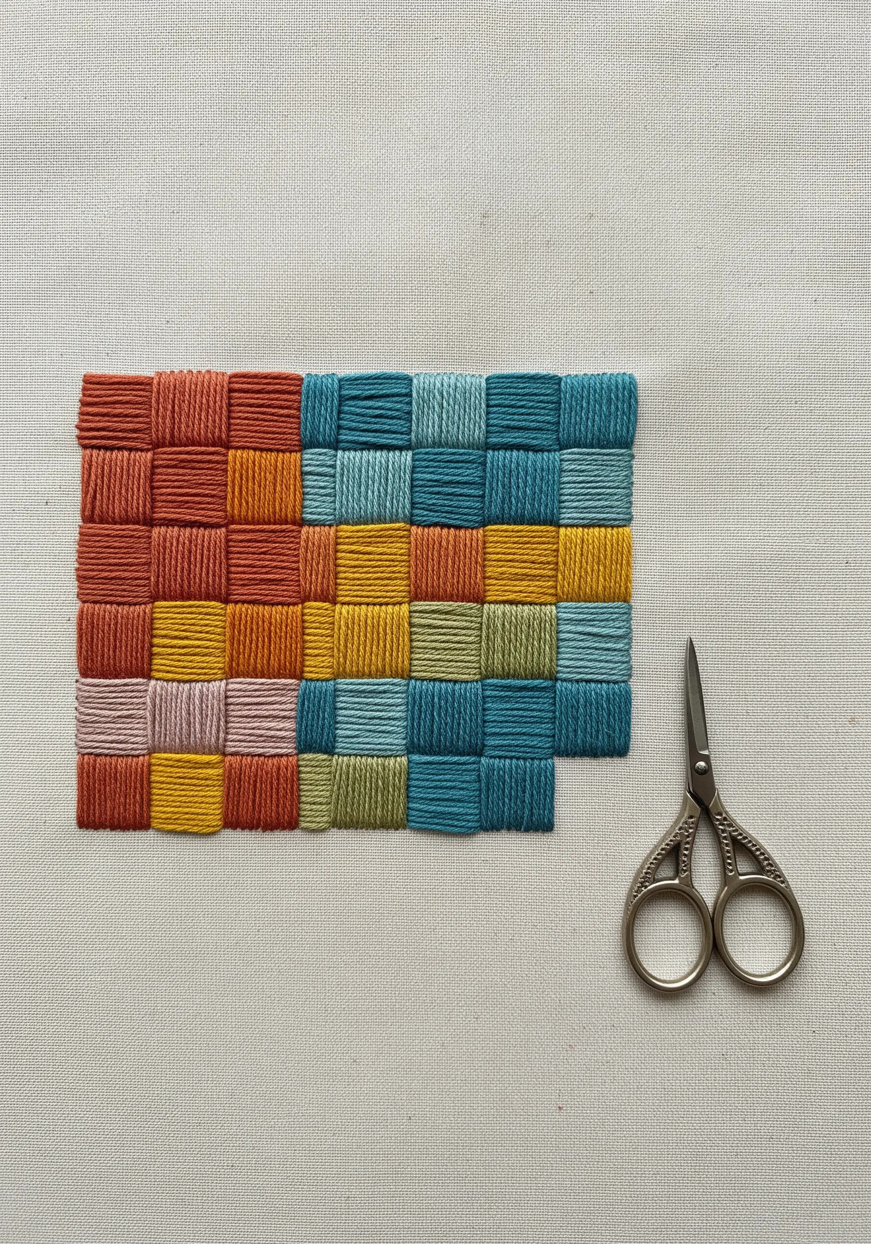 A color-blocked woven patch made with embroidery floss in earthy tones.