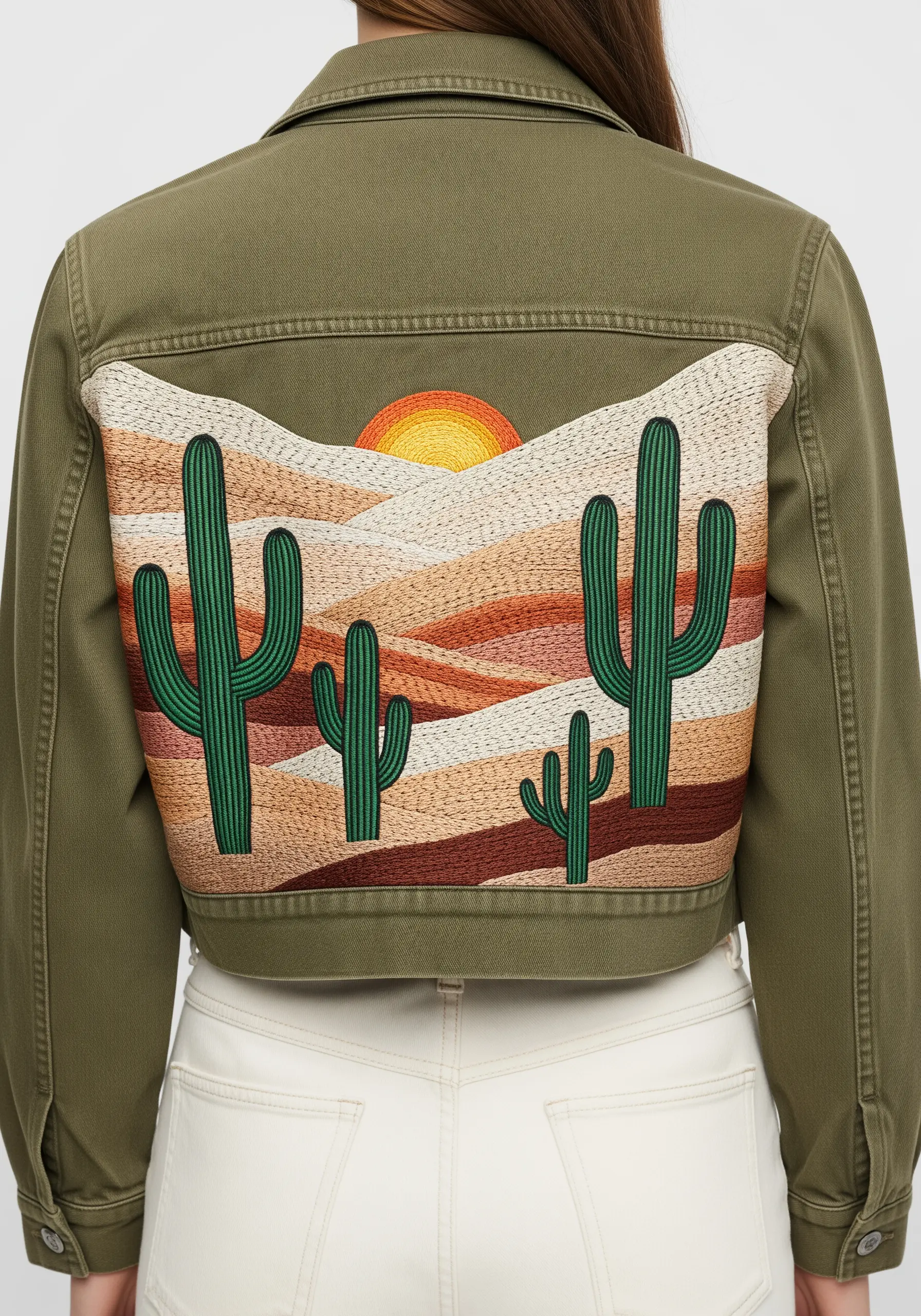 Abstract desert landscape with cacti embroidered on a panel on an olive jacket.