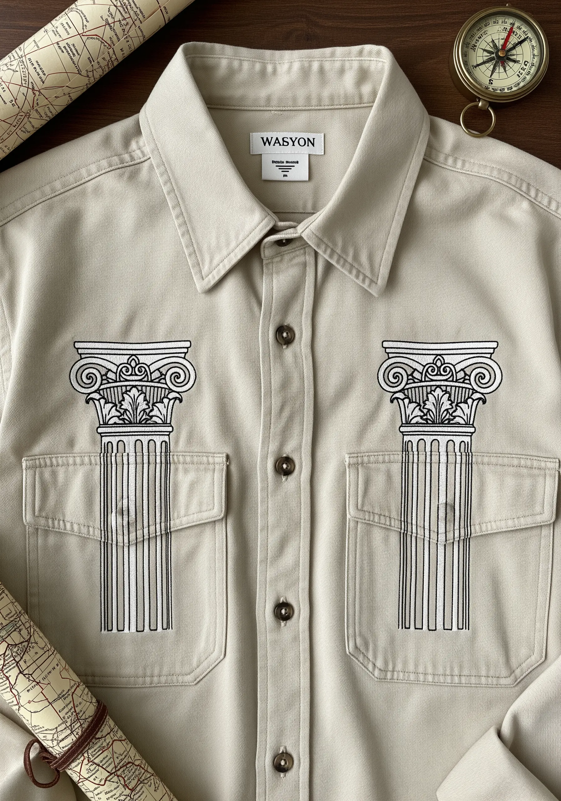 Two Greek-style columns embroidered in black and white on the front pockets of a beige work shirt.