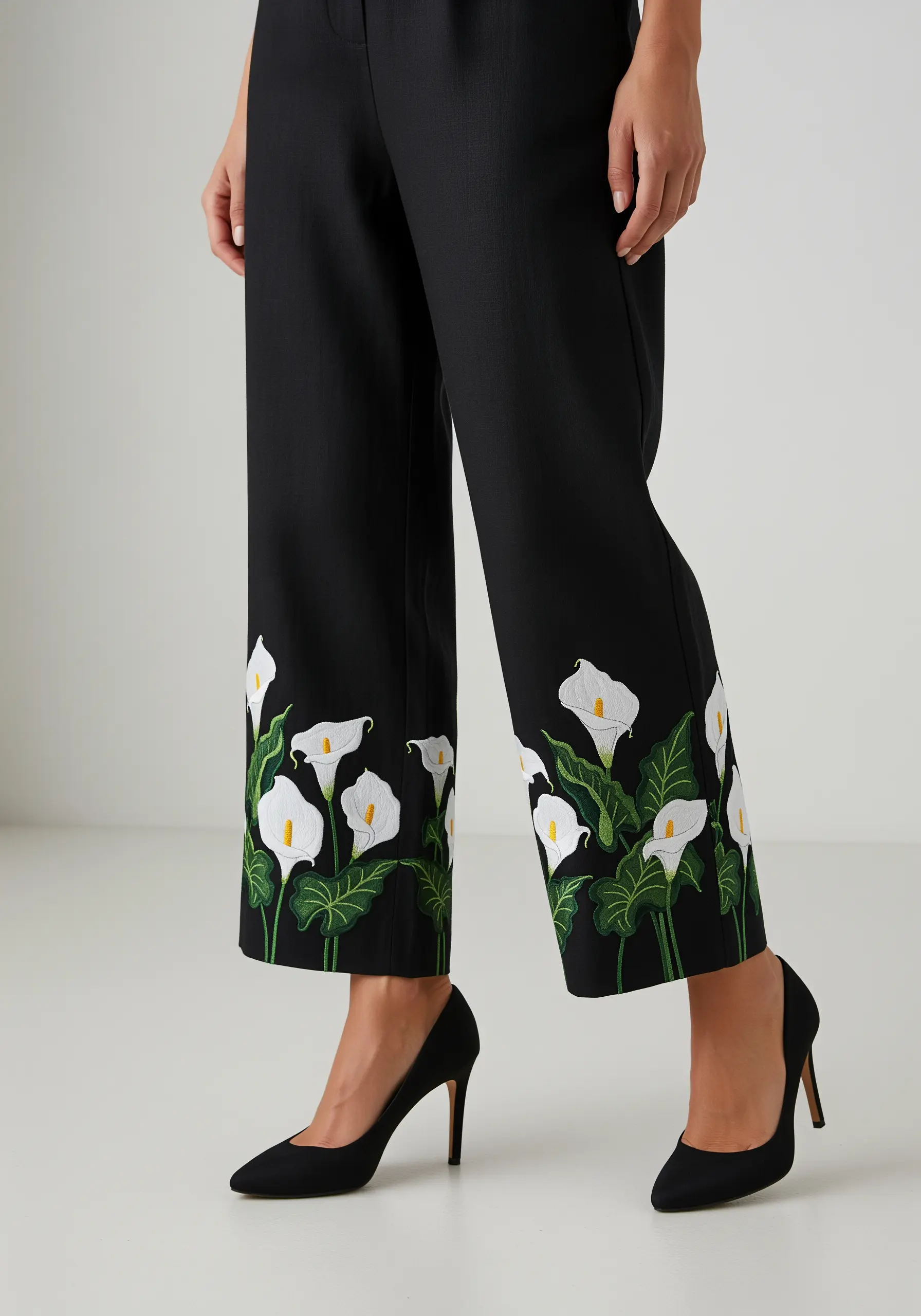 Elegant white calla lily embroidery on the hem of black wide-leg trousers