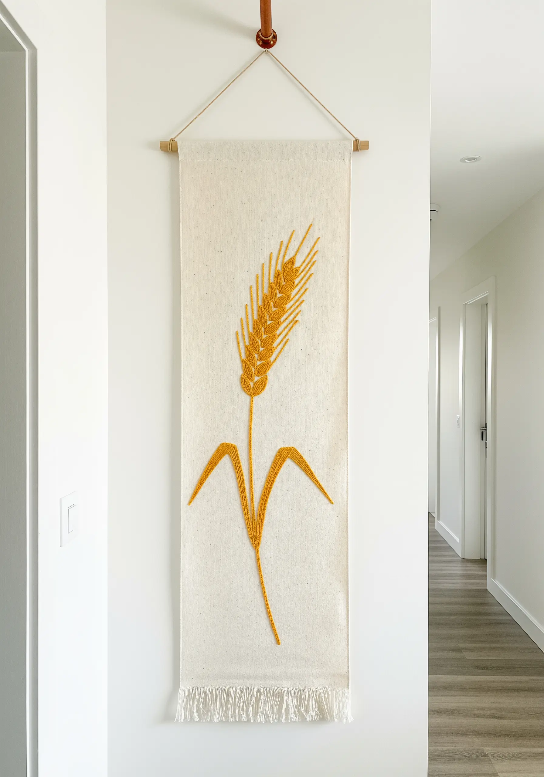 A simple wall banner with a single, golden stalk of wheat stitched in satin stitch.