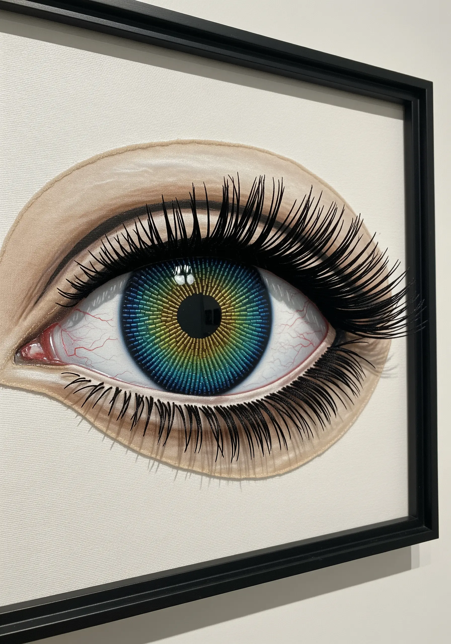 A hyperrealistic embroidered eye with a thread-painted iris and long, 3D false eyelashes.
