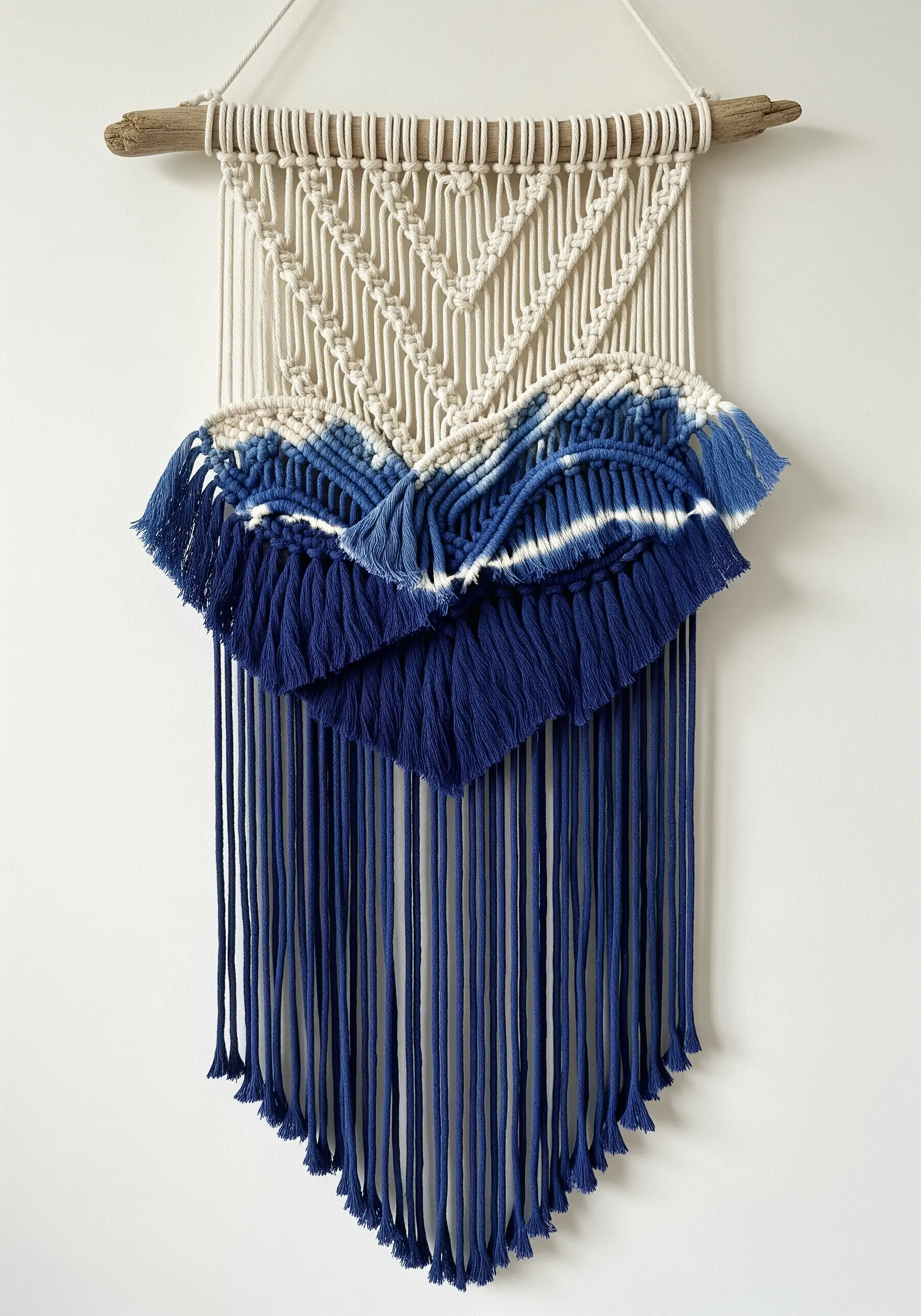 Macrame wall hanging with a blue dip-dyed section creating an ombré and tie-dye effect.