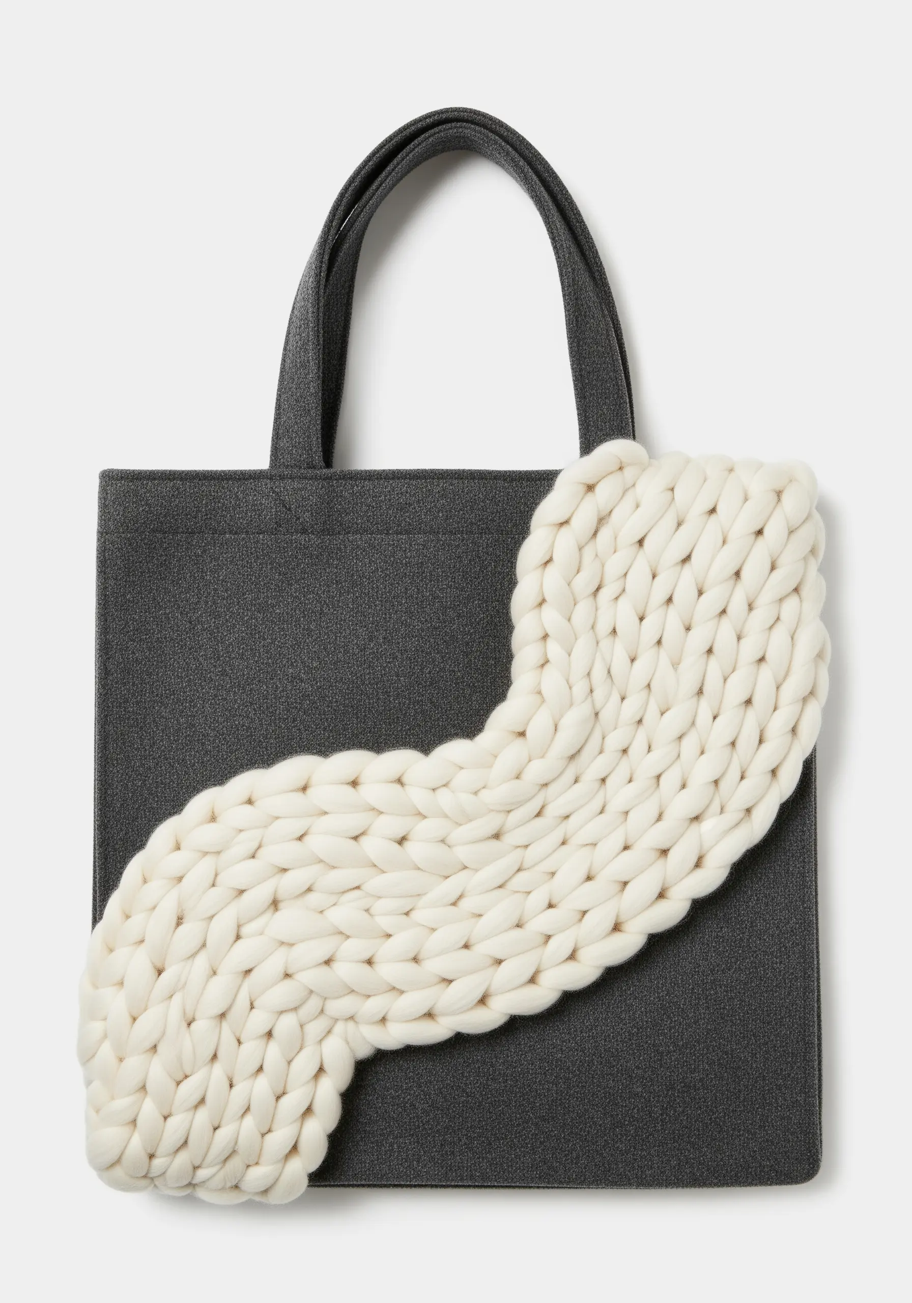 A gray tote bag with a large, chunky white knit accent appliquéd to the front