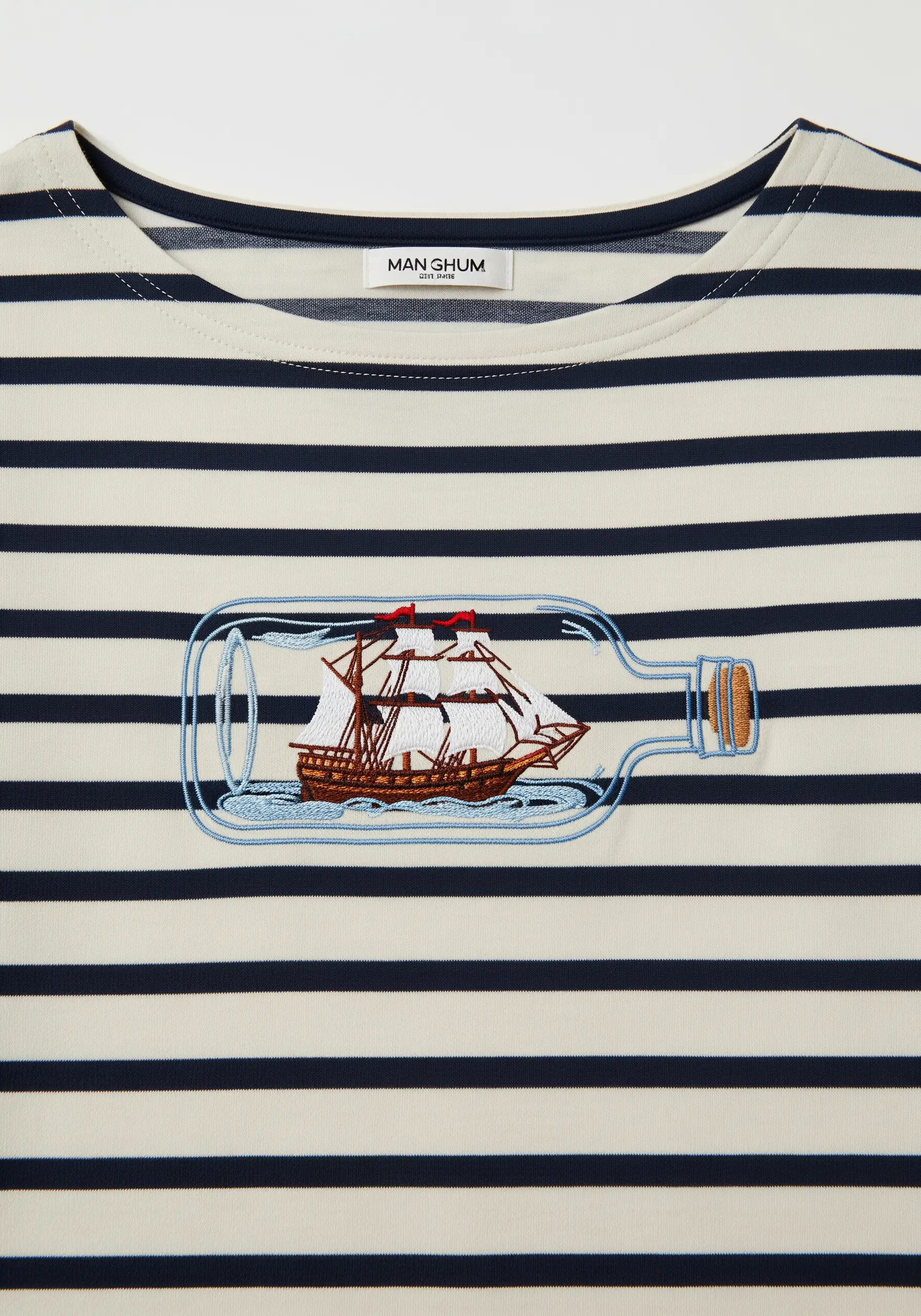 Embroidery of a ship in a bottle on a blue and white striped nautical shirt.