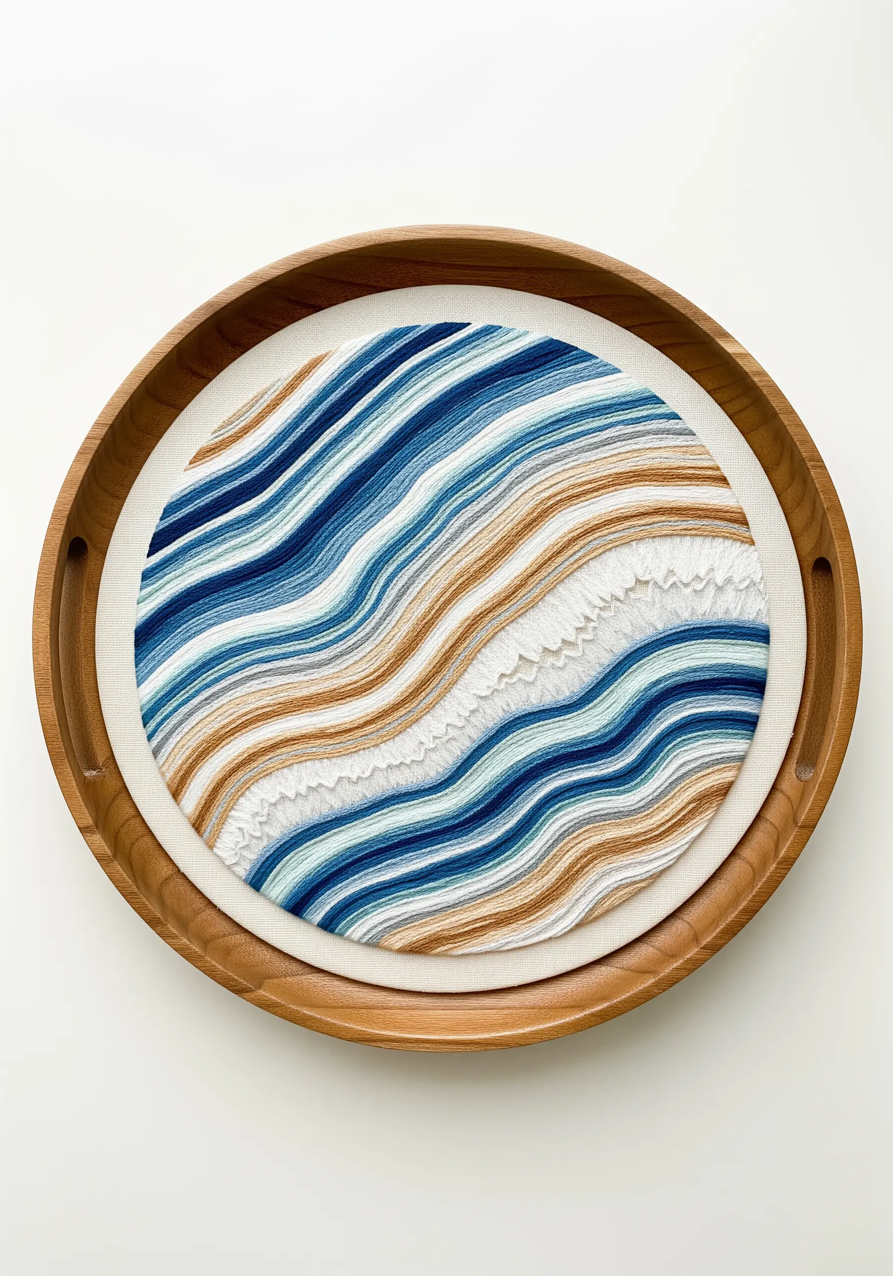 Abstract embroidery with flowing blue, white, and brown lines resembling agate or waves.