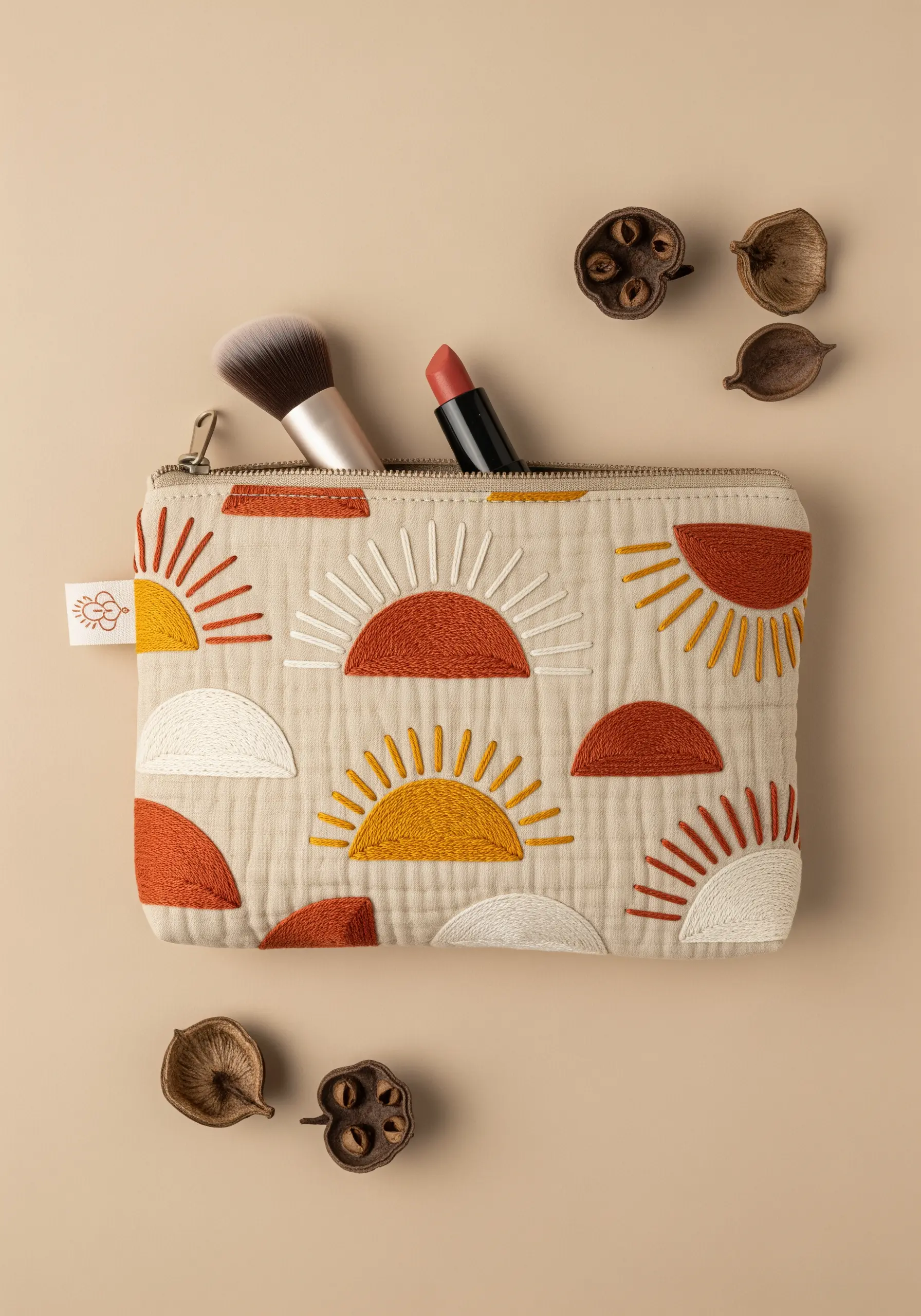 A quilted pouch decorated with appliqué and embroidered suns in terracotta, yellow, and white