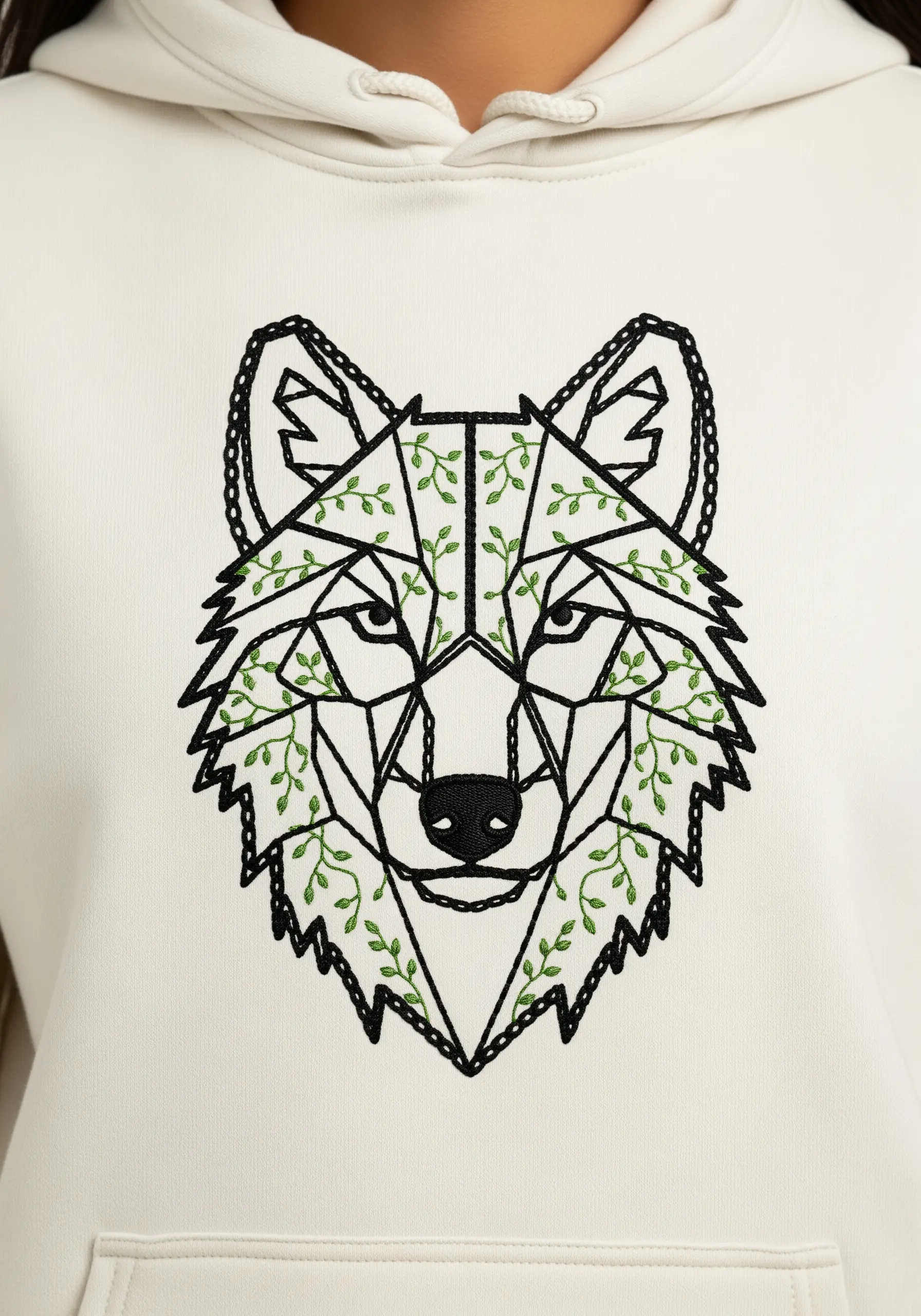 A geometric wolf outline filled with delicate green vines on a white hoodie.