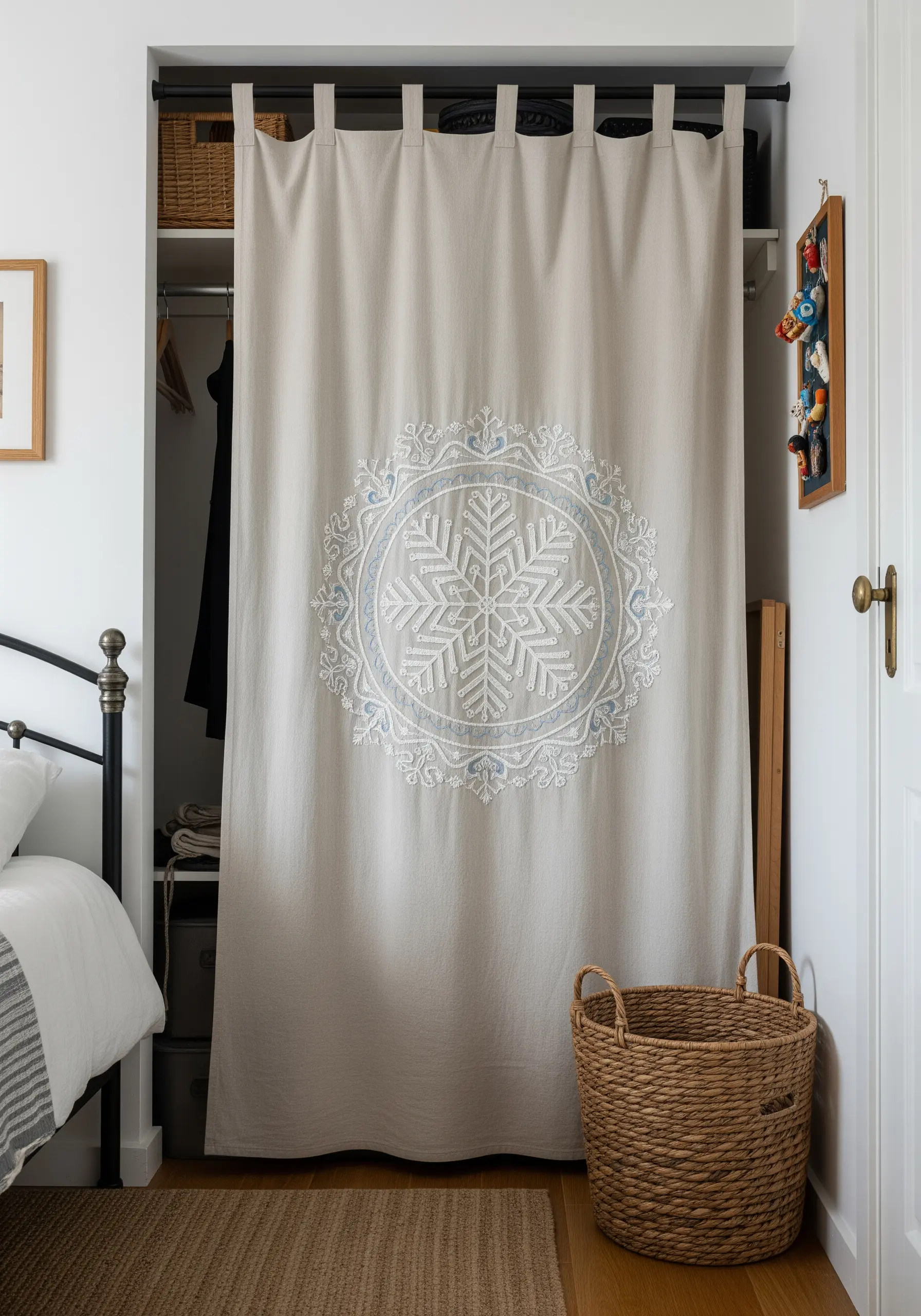 A large snowflake mandala embroidered in white and blue on a linen closet curtain.