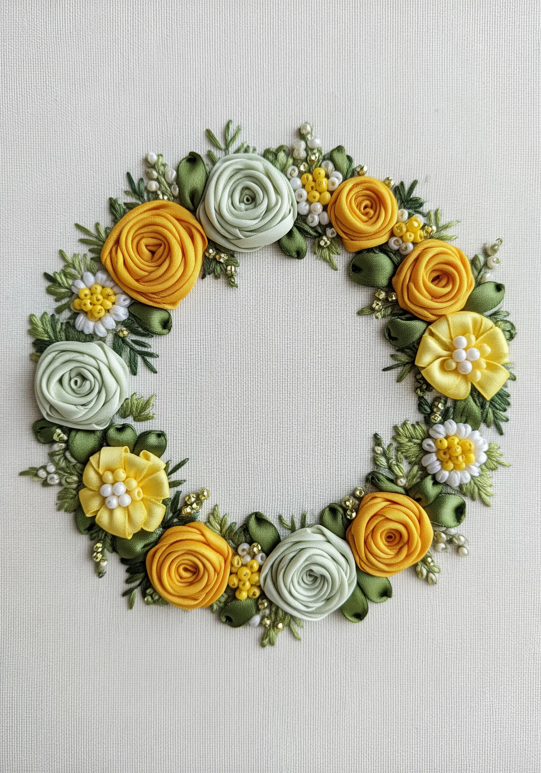 A floral wreath made with yellow and green satin ribbons, creating dimensional roses and leaves.