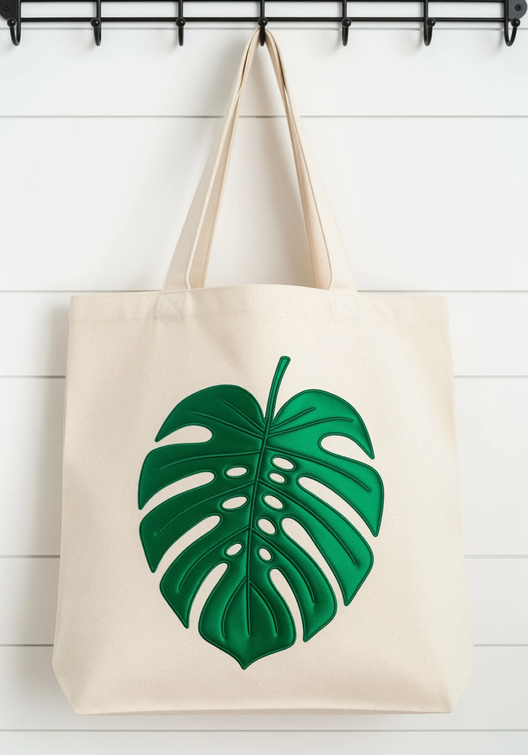 Canvas tote bag with a large, 3D embroidered green Monstera leaf.