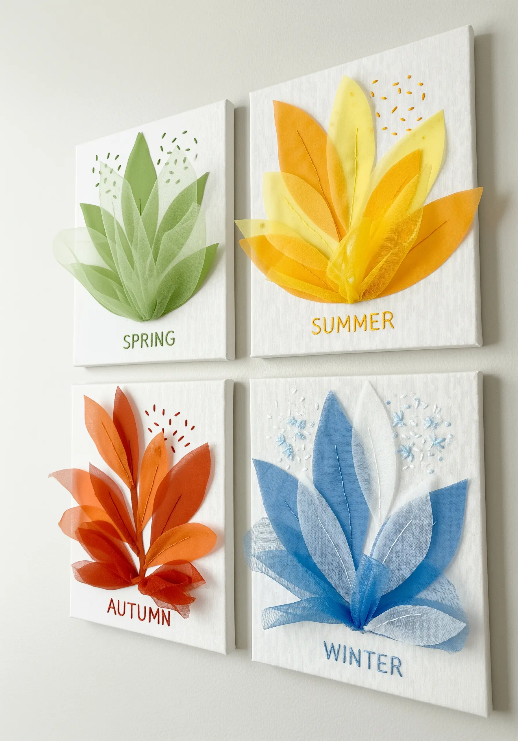 Four canvases representing seasons, each with 3D leaf shapes made from pinched sheer fabric.