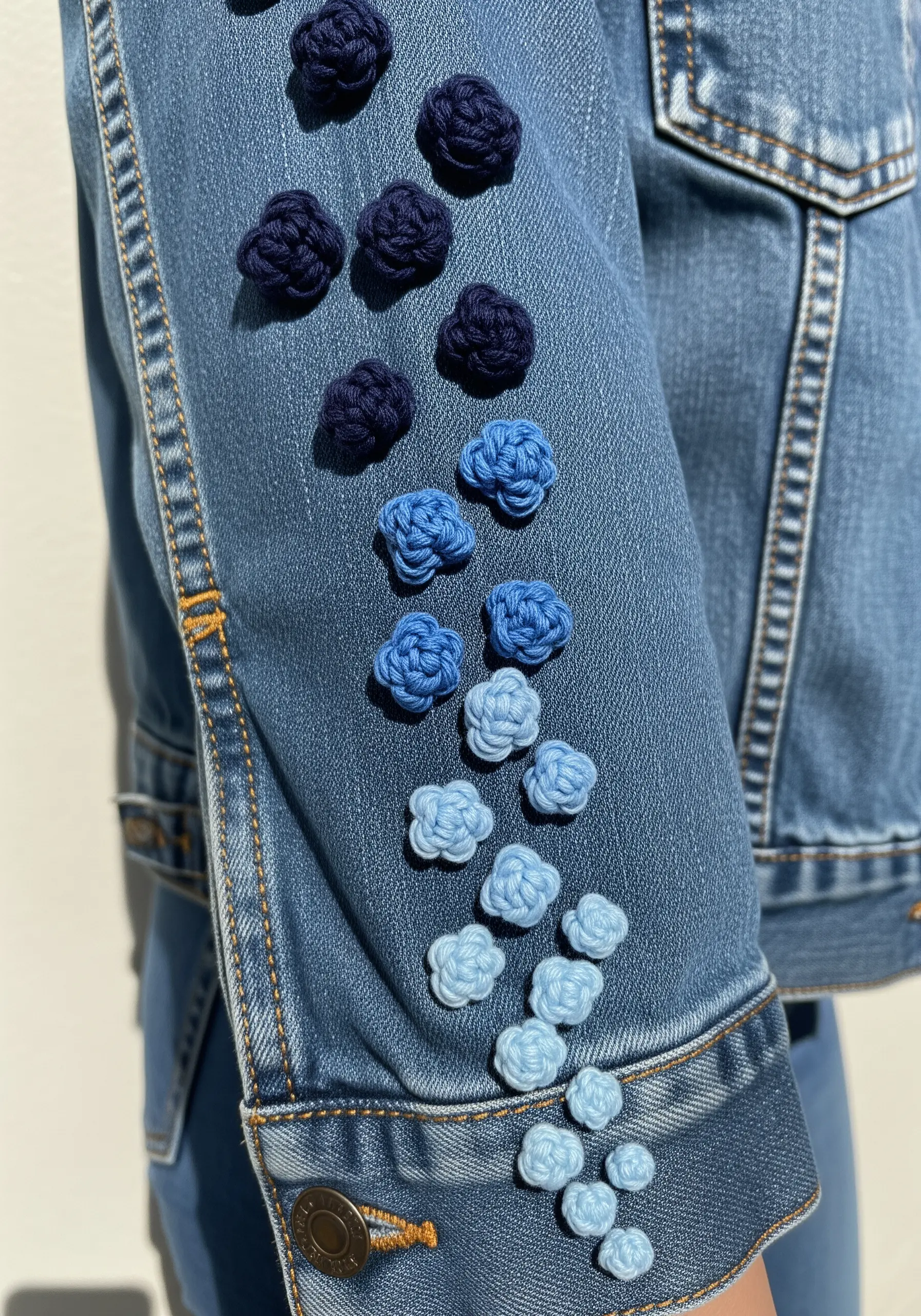A sleeve decorated with 3D woven knots in a gradient from dark blue to light blue.